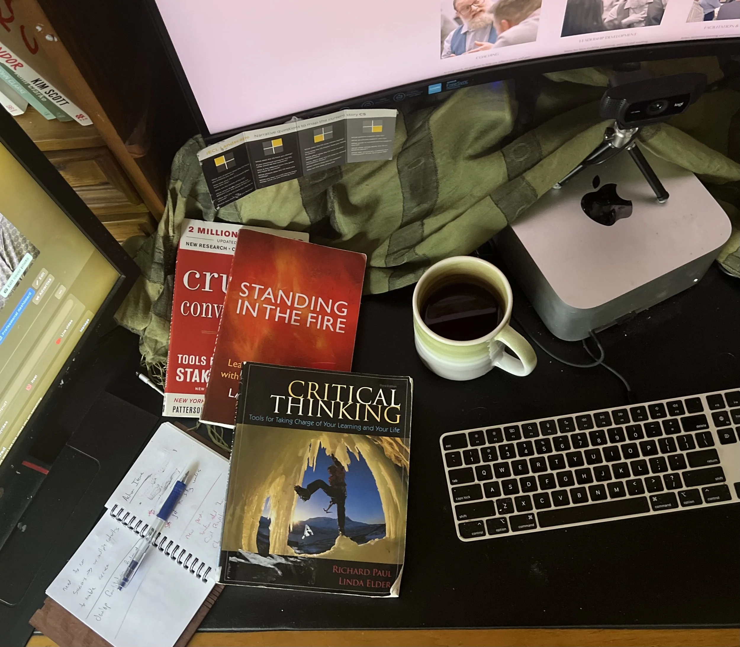 A book, notepad, pen, cup of tea, and a computer, all side by side, representing traditional authorship and modern writing tools
