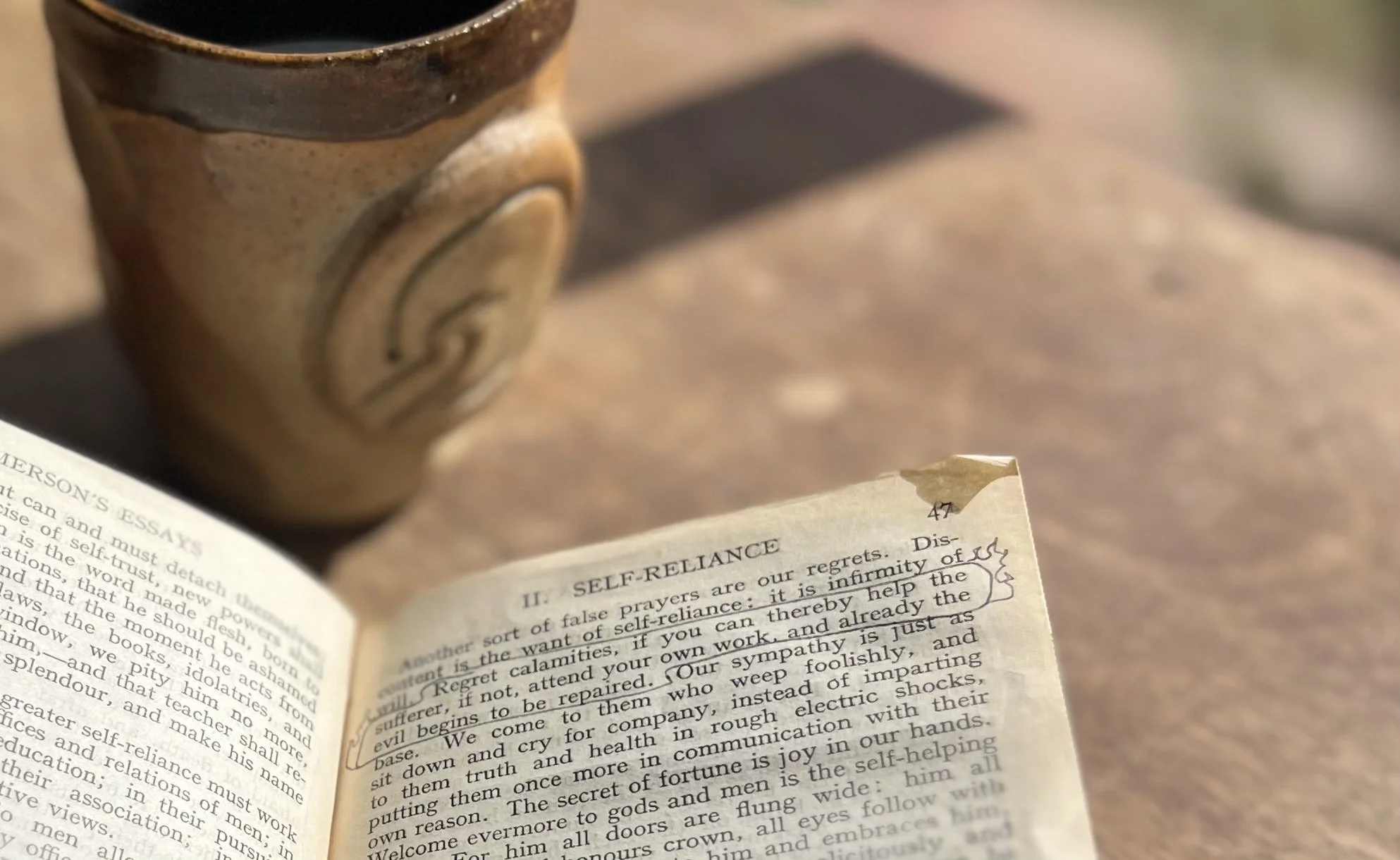 Emerson essay open to passage about doing your work, teacup in back ground