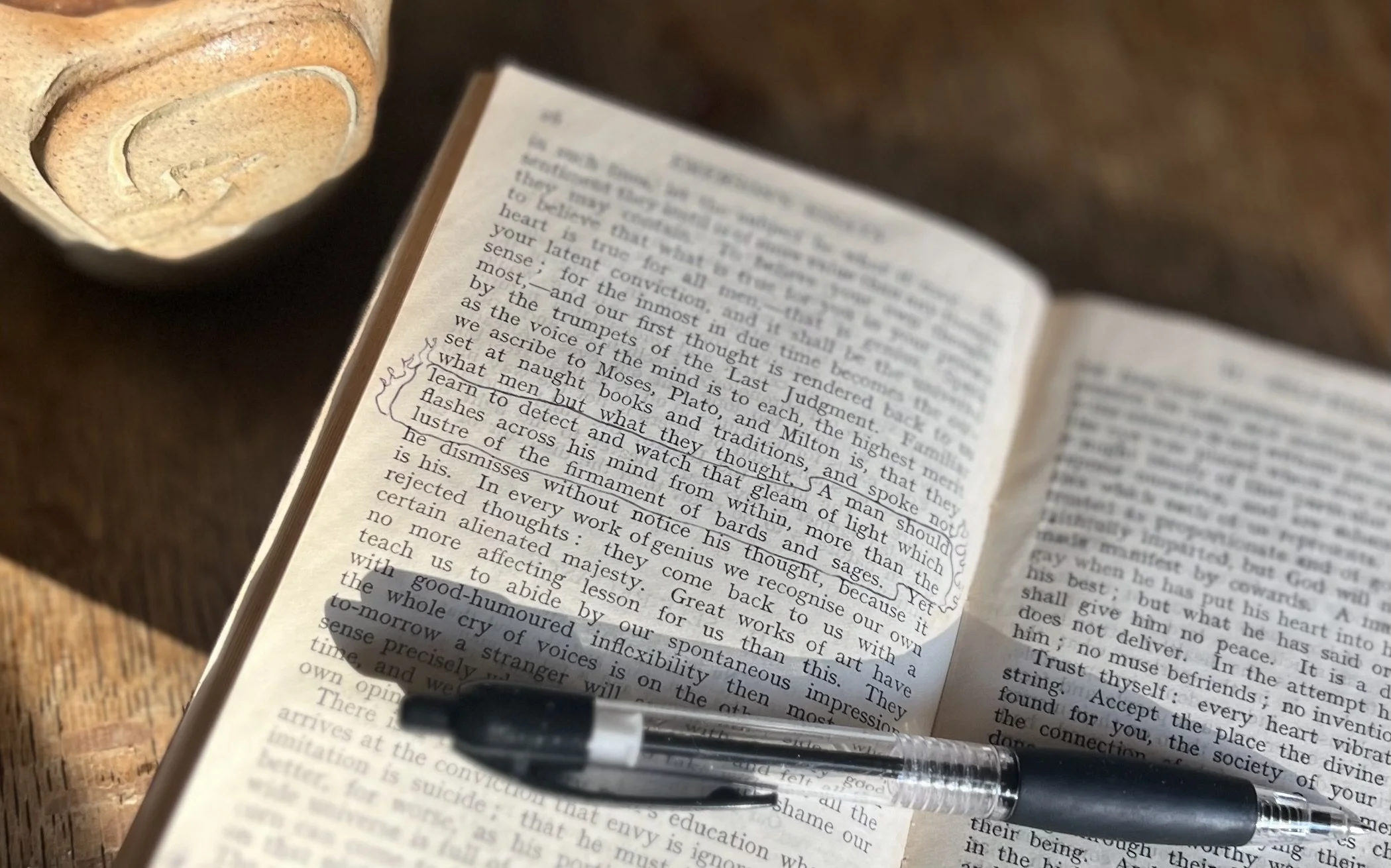 Open Emmerson essay showing highlighted passage about inner light, tea cup in background