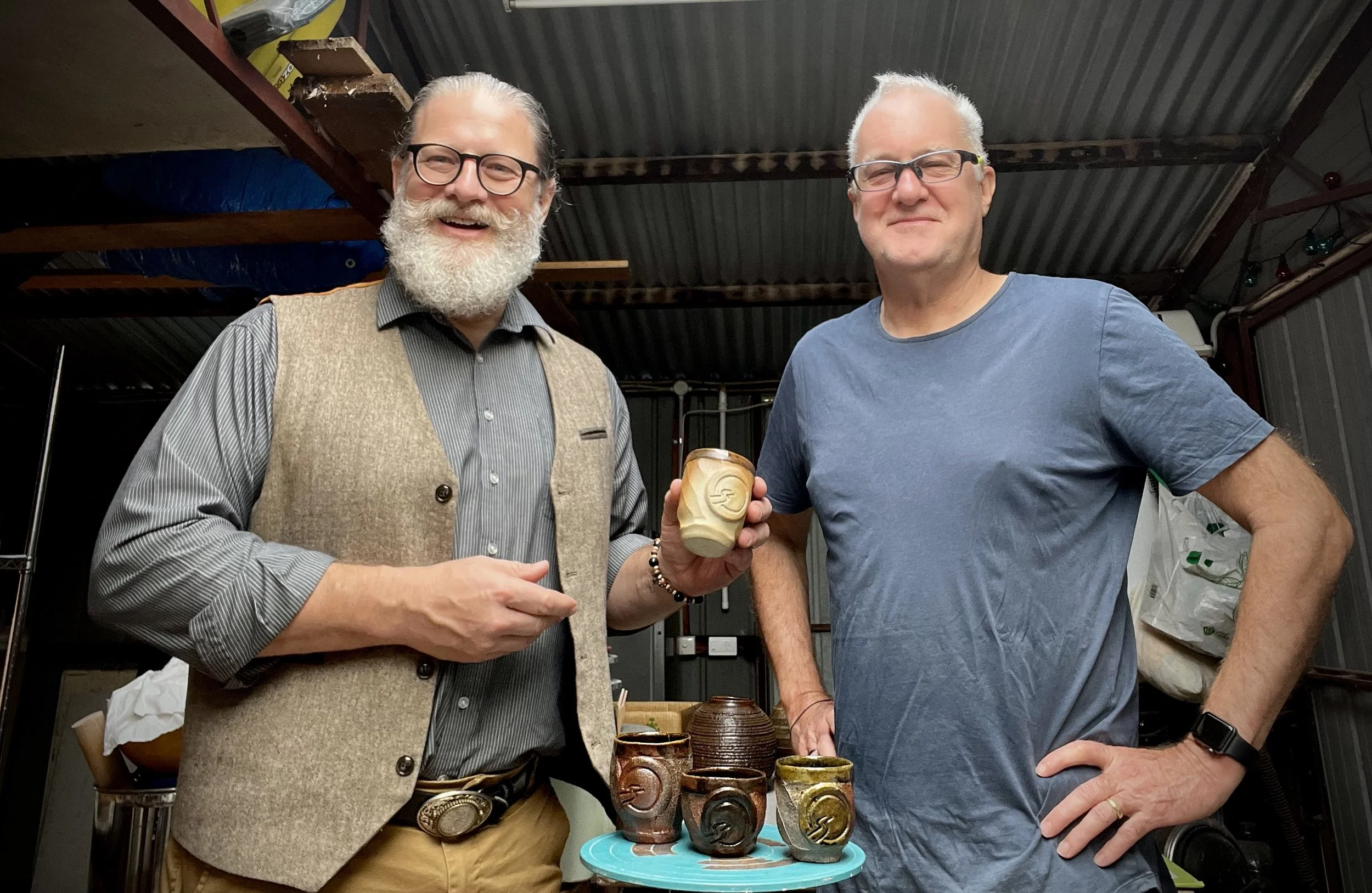 James Samana (founder of Insightful Path) and Trevor Heldt - the Potter inside his studio, with the commissioned work of four hand made wood fired cups.