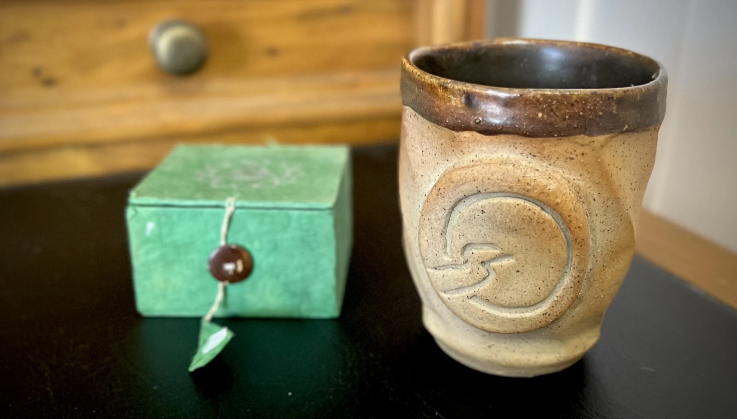 Meditation bell and handmade teacup representing reflective practice, mindfulness, and facilitator self-awareness