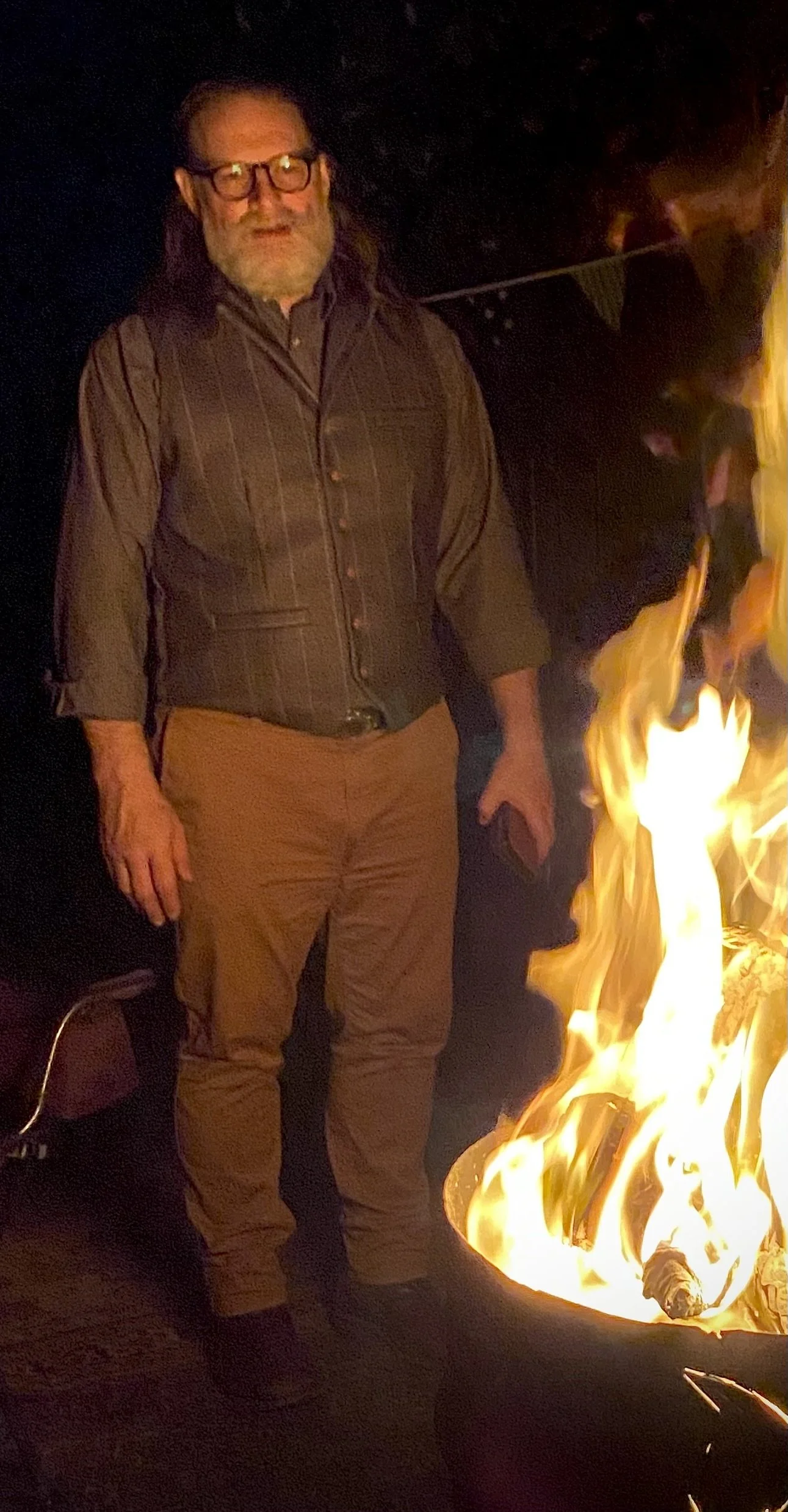 James watching a bonfire, symbolising tension, presence, and the facilitators choice to stay with productive conflict