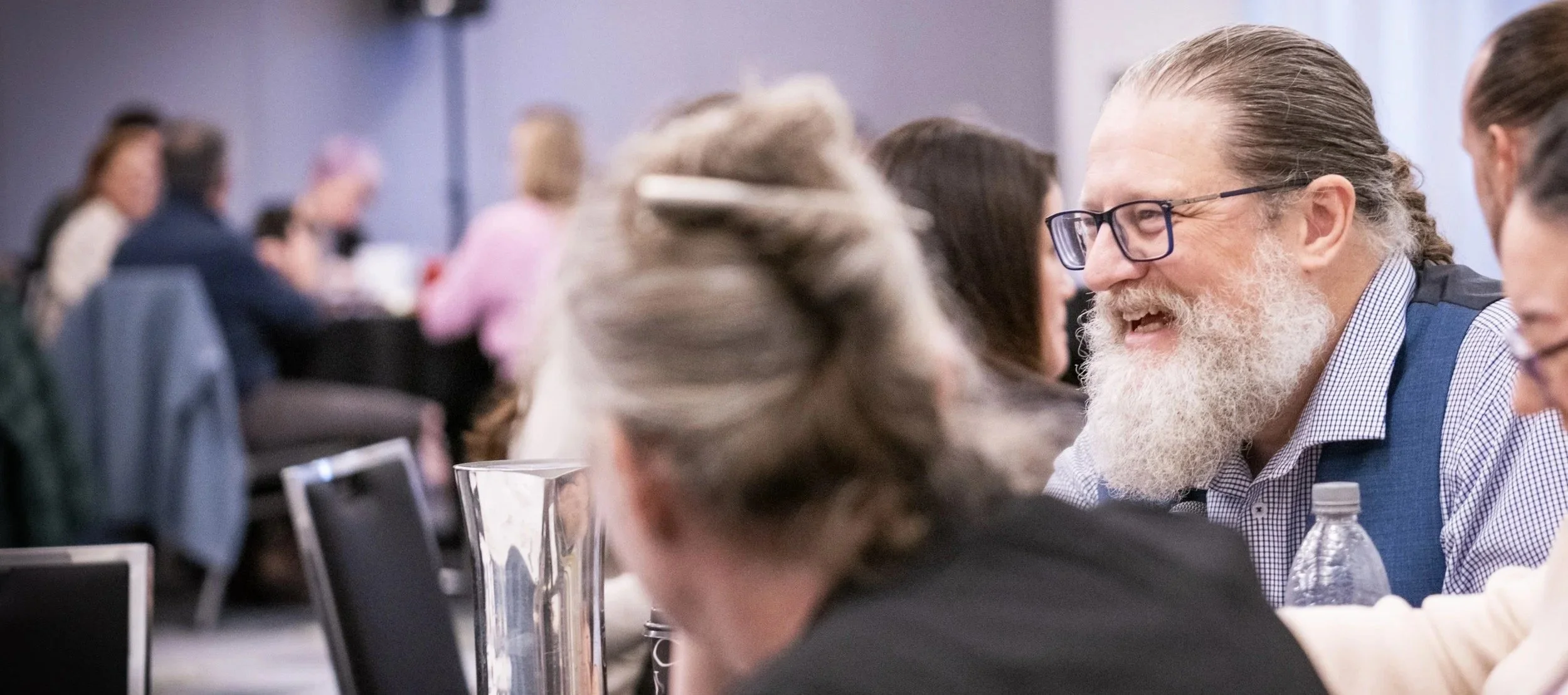 Image of smiling people talking at a table in a workshop
