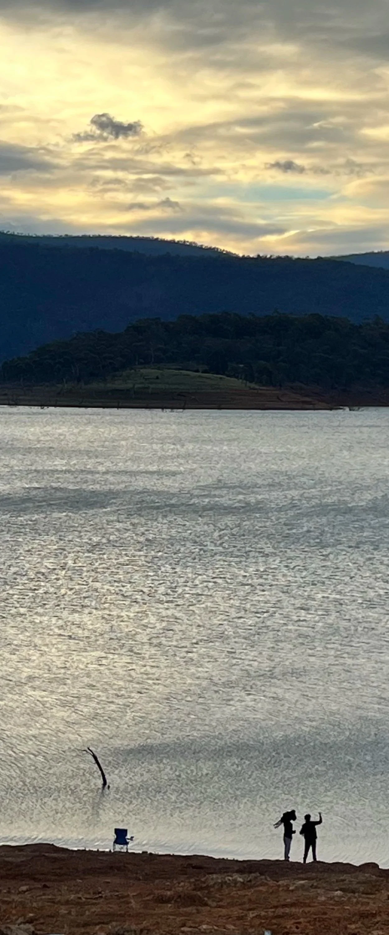 Two boys talking and fishing at sunset: still water, mountains, and the slow pace of a real exchange
