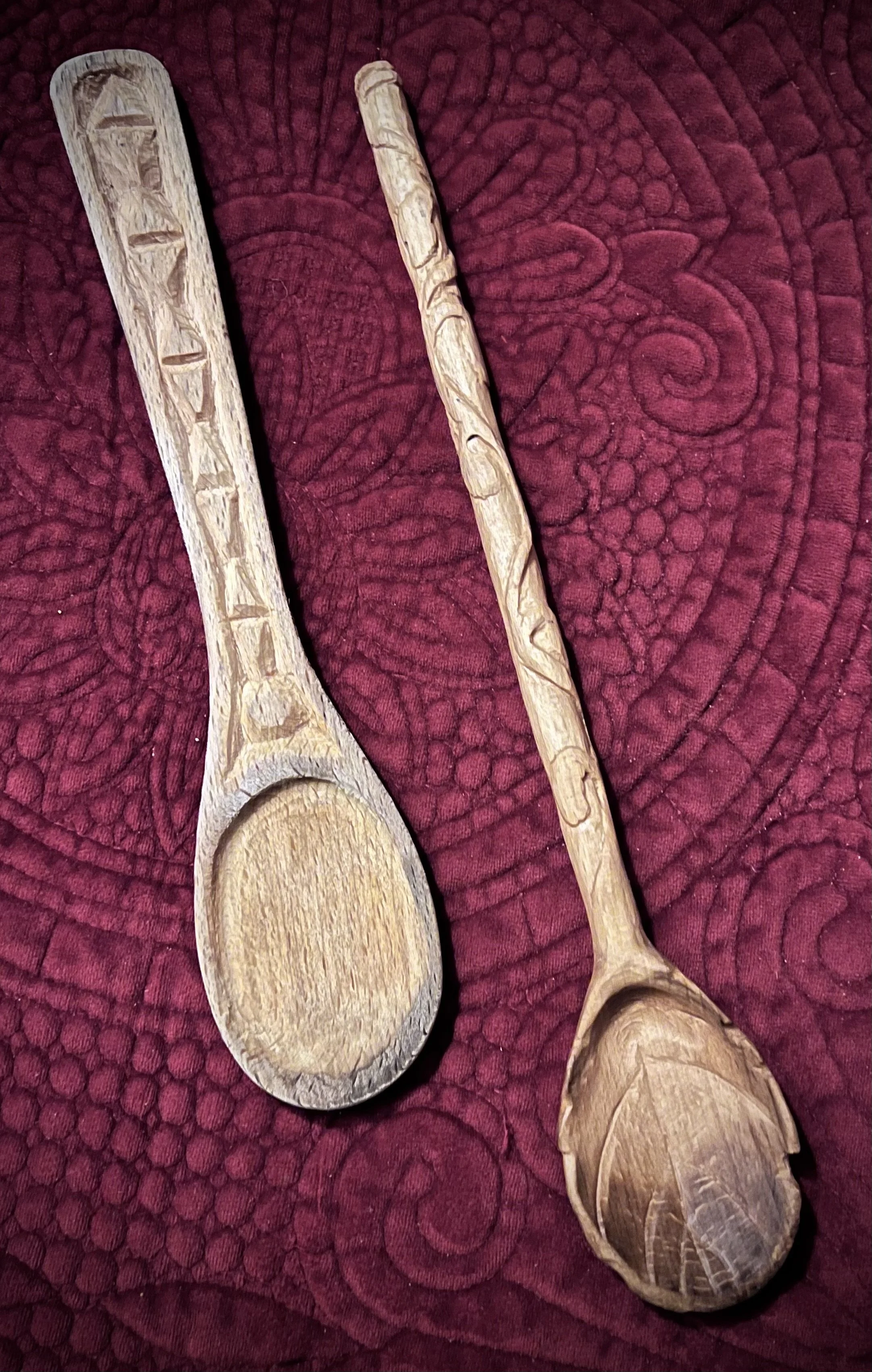 Two wooden carved spoons, one more sanded than the other, both before the final finish.