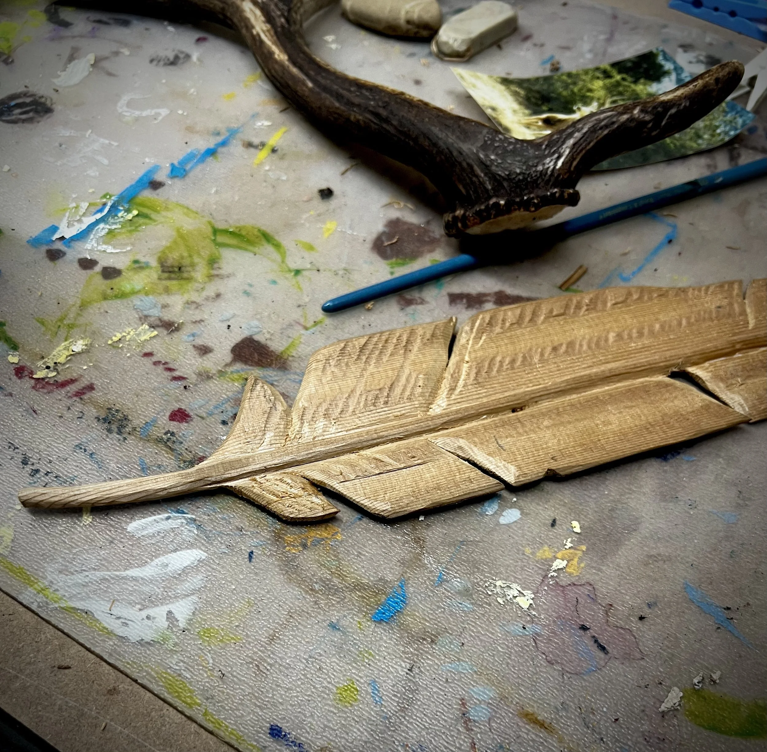 Detailed view of a finished wooden feather showing symmetry, craftsmanship, and refined carving