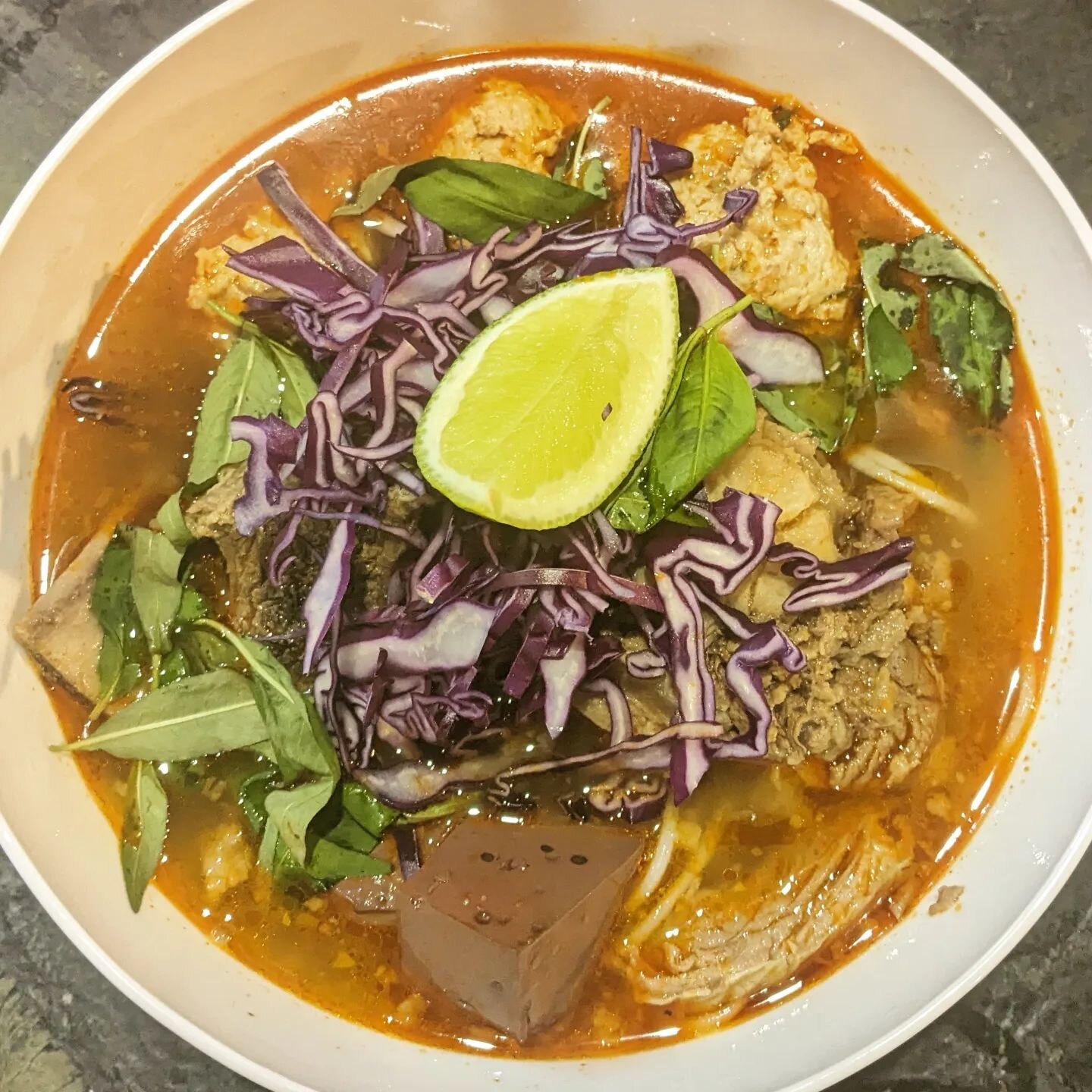 B&uacute;n B&ograve; Huế - Spicy beef noodle soup
with homemade bouncy chả lụa meatballs, brisket, oxtail, pig blood, cabbage, herbs, lime and the signature lemongrass, garlic, shallot and annatto BBH oil on top

Not something my family ever made at 