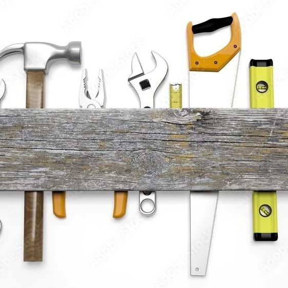 Collection of hand tools including a hammer, pliers, adjustable wrench, measuring tape, handsaw, and spirit level, arranged behind a wooden plank.