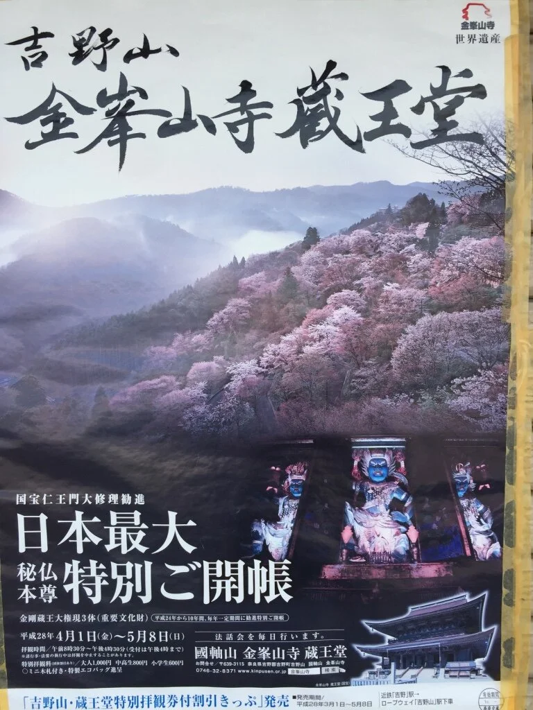 A promotional poster featuring a scenic mountain landscape with cherry blossoms and traditional Japanese temple statues. The text is in Japanese with some Chinese characters, highlighting a special opening event at Kimpusen-ji temple.