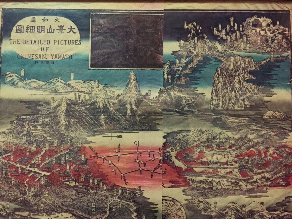 A traditional Japanese illustrated map titled 'The Detailed Pictures of Unnesan Yamato,' showing mountains, rivers, buildings, and roads with labels, in blue, black, and red ink.