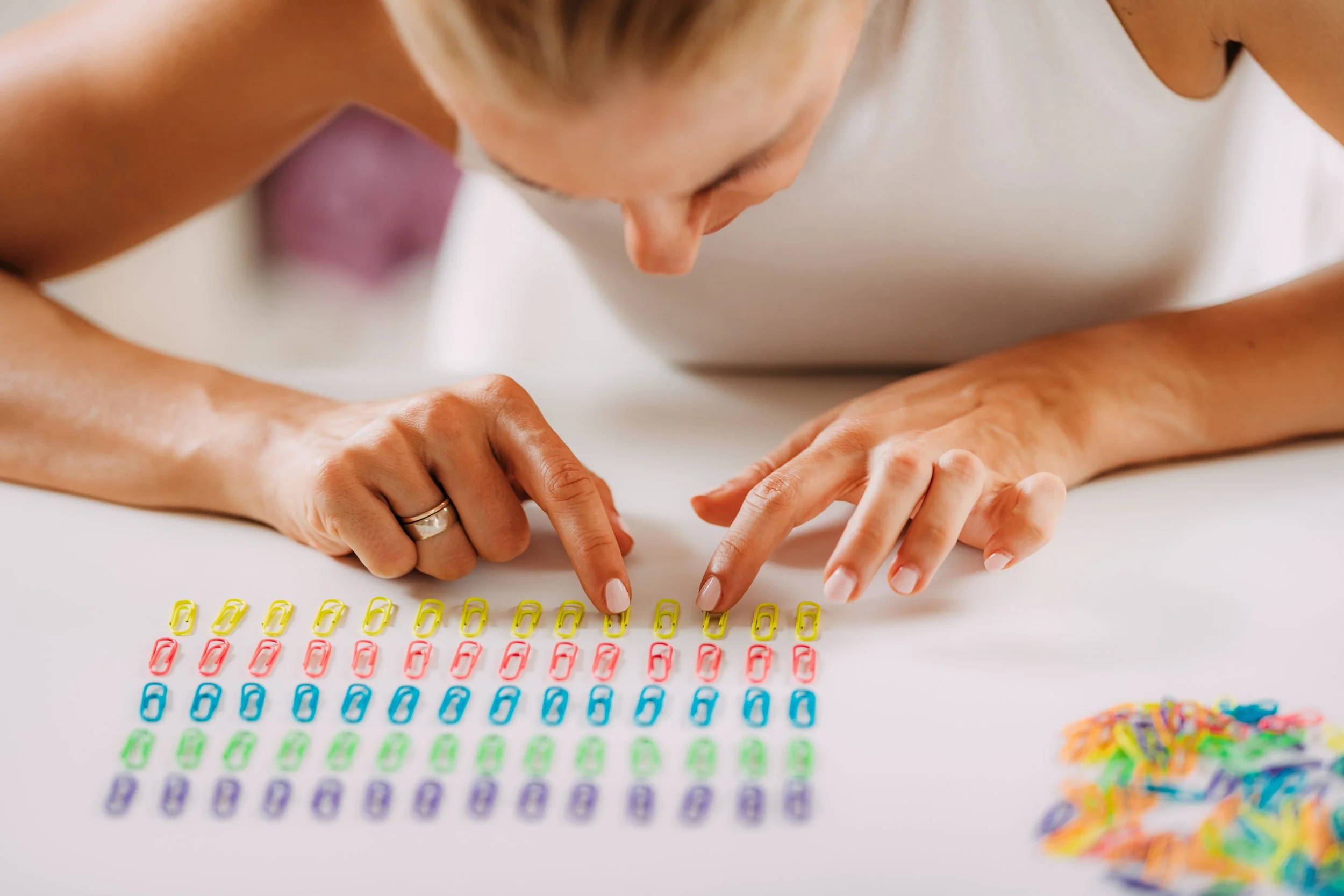 Woman arranging staples in colour order