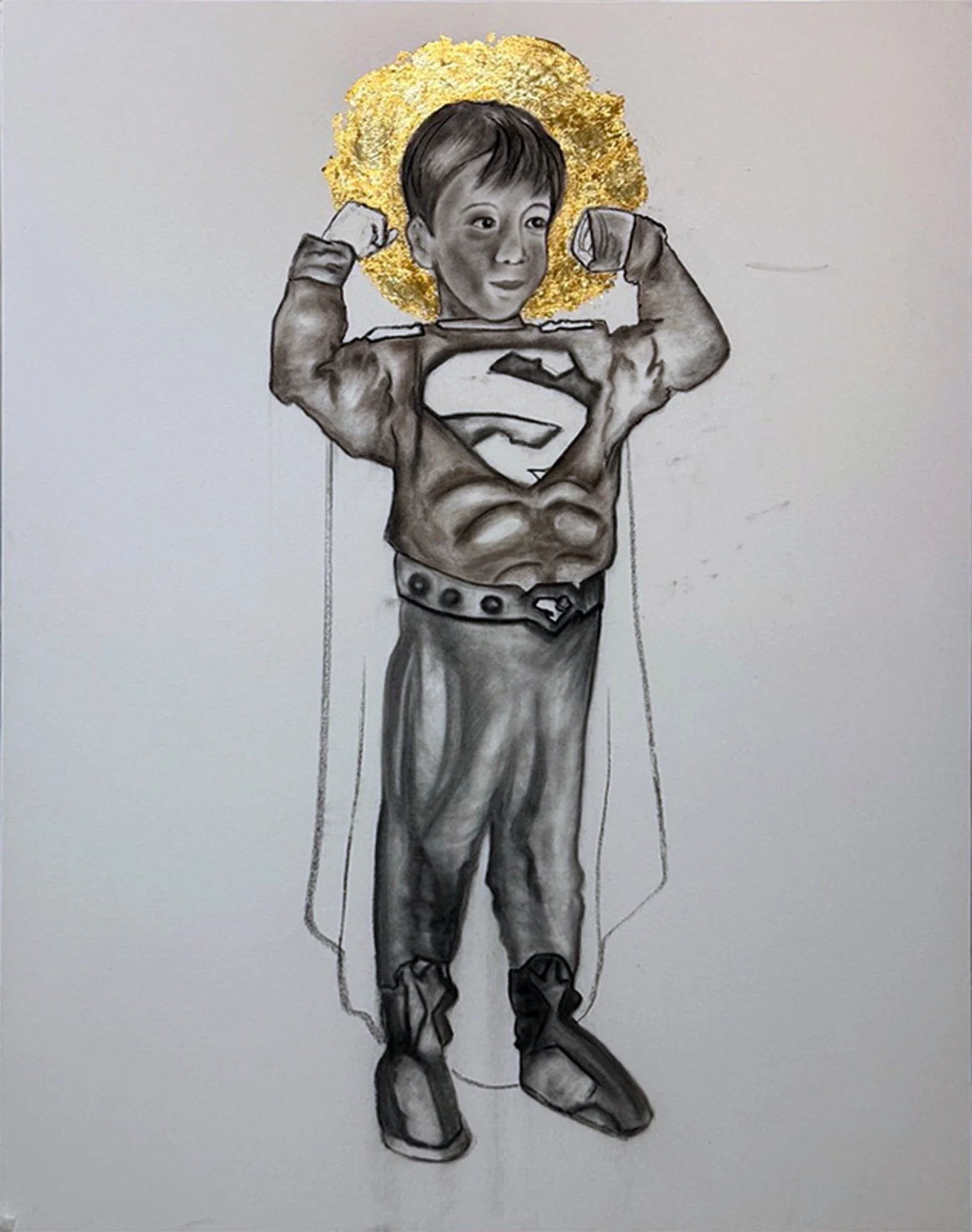A drawing of a child dressed as Superman, showing a muscular chest with the Superman logo, wearing a cape, pants, boots, and a golden halo-like circle behind their head, with arms flexed in a superhero pose.
