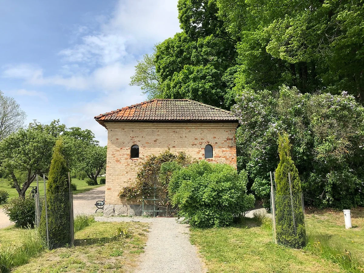 Litet stenhus i Tyresö slottspark omgiven av grönska – bröllopsfoto Tyresö