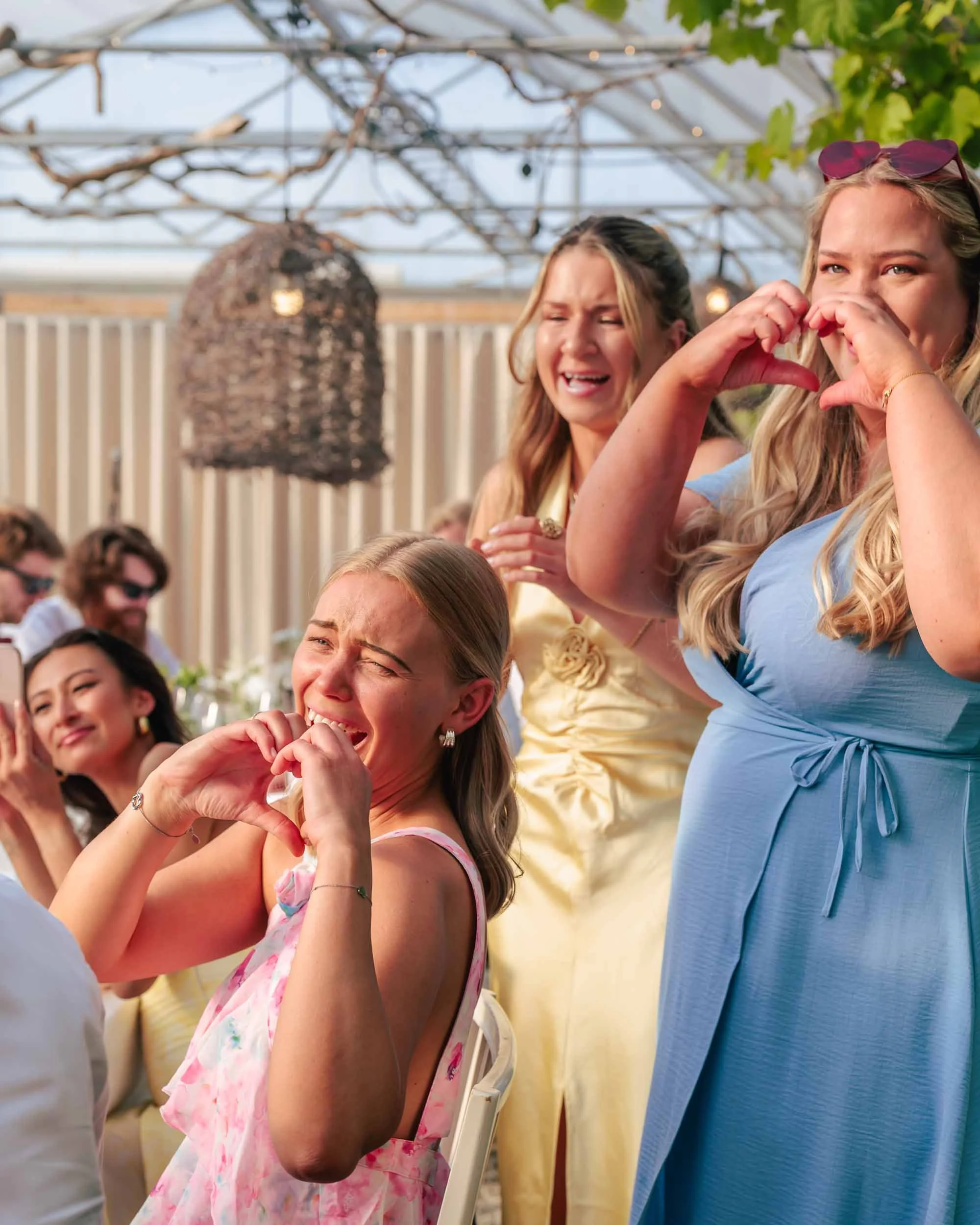 Bröllopsfoto Högbo Brukshotell – gäster formar hjärtan under bröllopsfest.