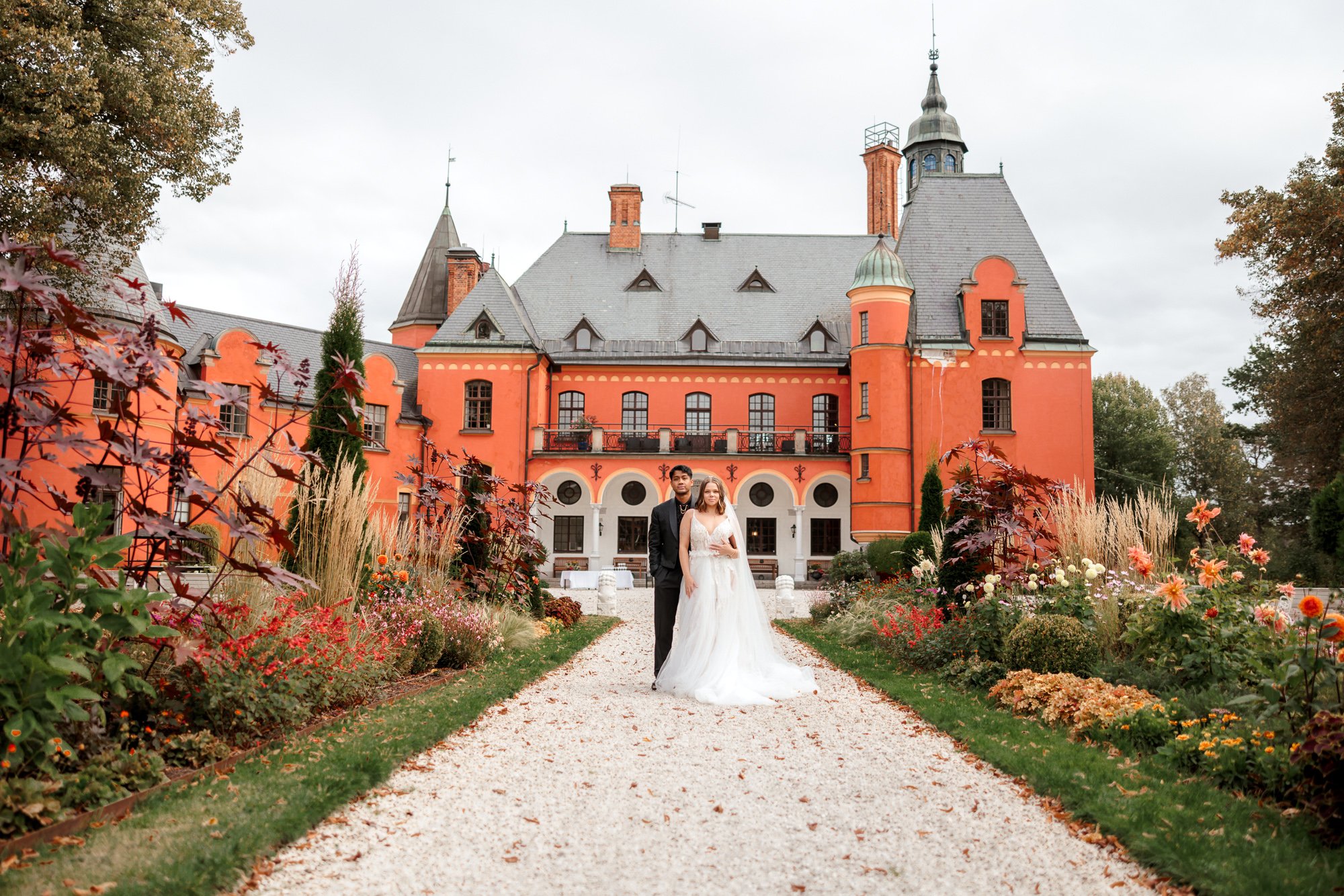 Bröllopspar i slottsträdgård med höstblommor – bröllopsfoto slott Stockholm