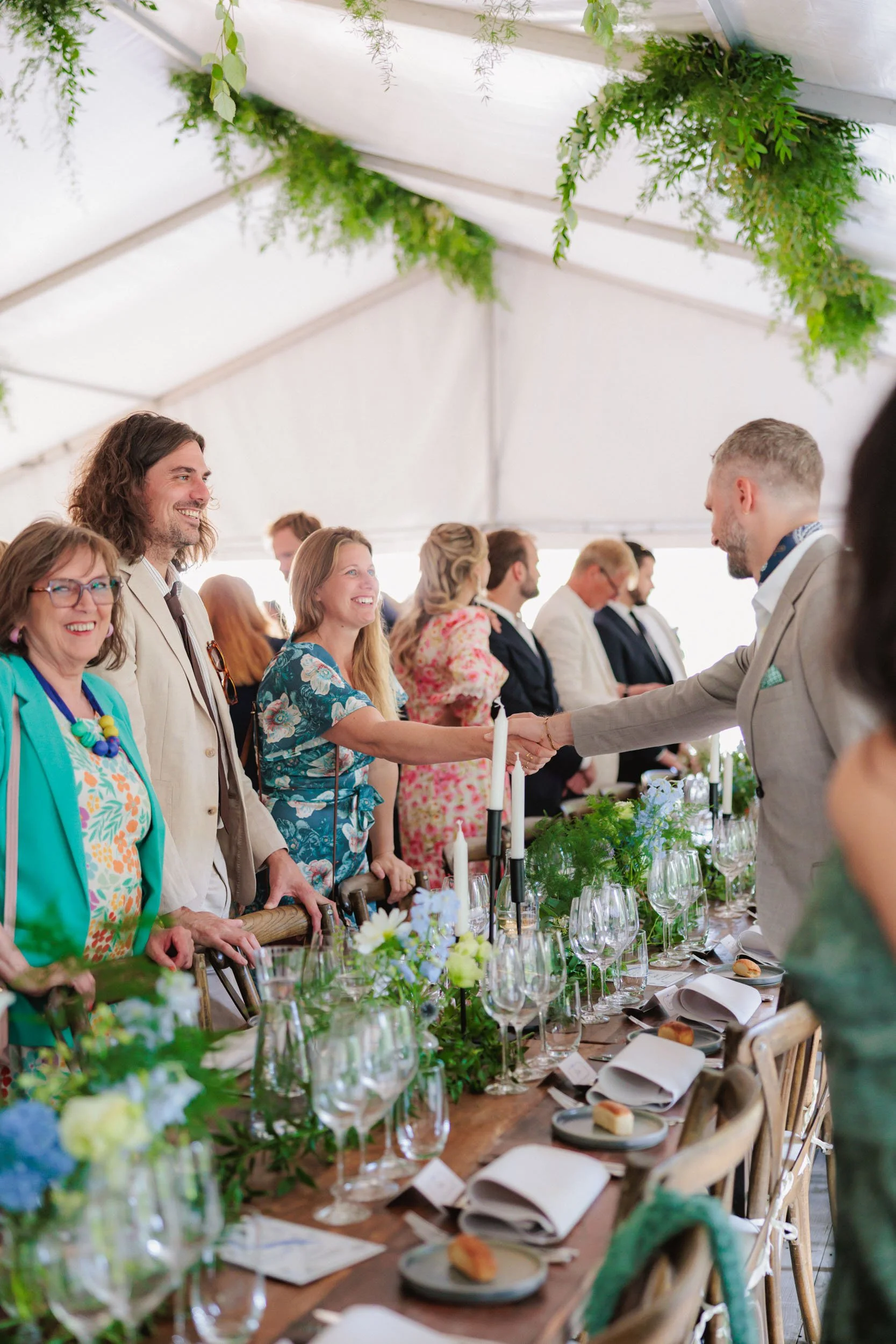Väldigt sammansatt bordsinstallationen med blommor, glass, ljus och dukar.