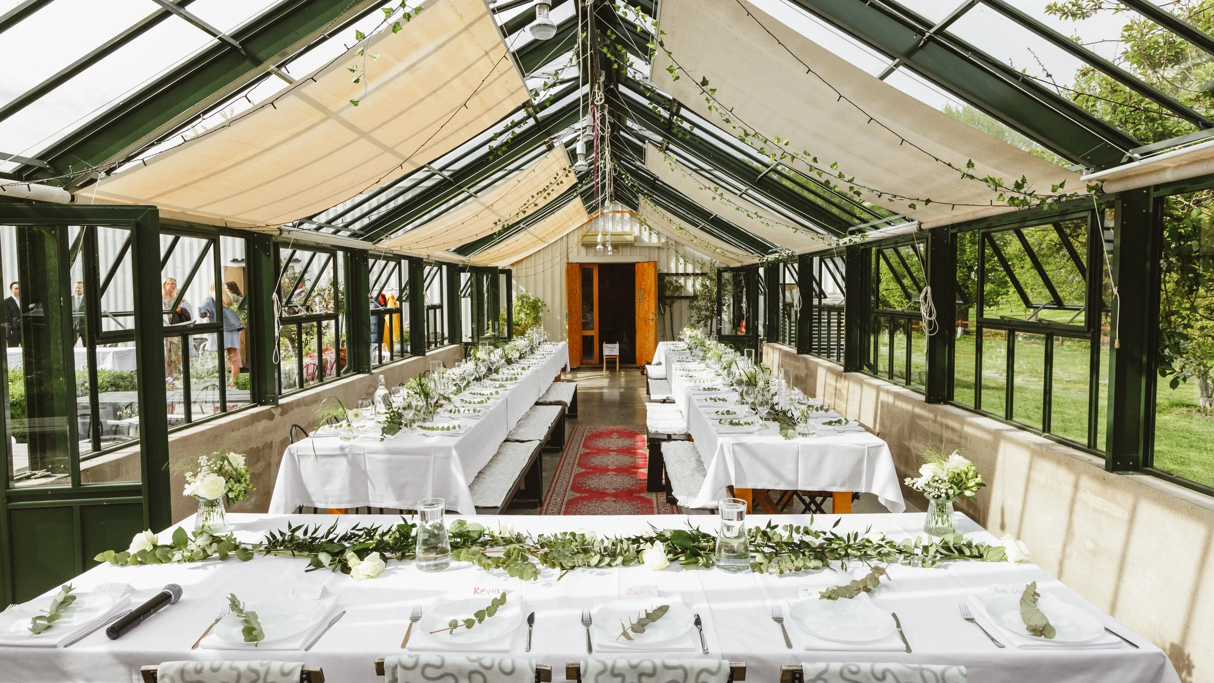 Dukat växthus med långa bord och blommor – bröllopslokal planera bröllop Sverige