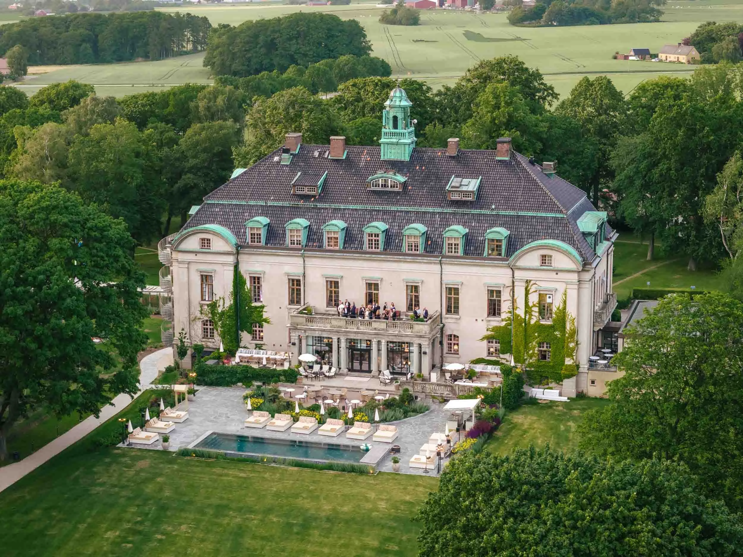 Drönarvy över slott med pool och park – bröllopslokal kostnad Sverige
