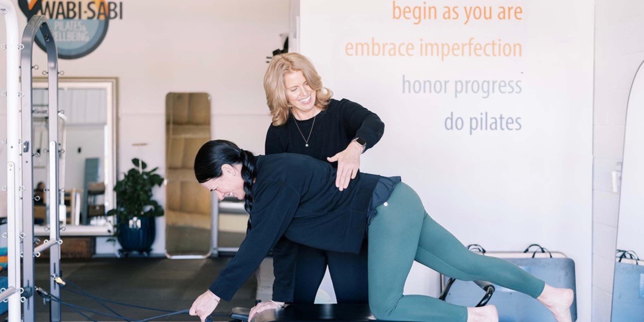 Wabi Sabi Pilates' owner guiding a student during a workout session