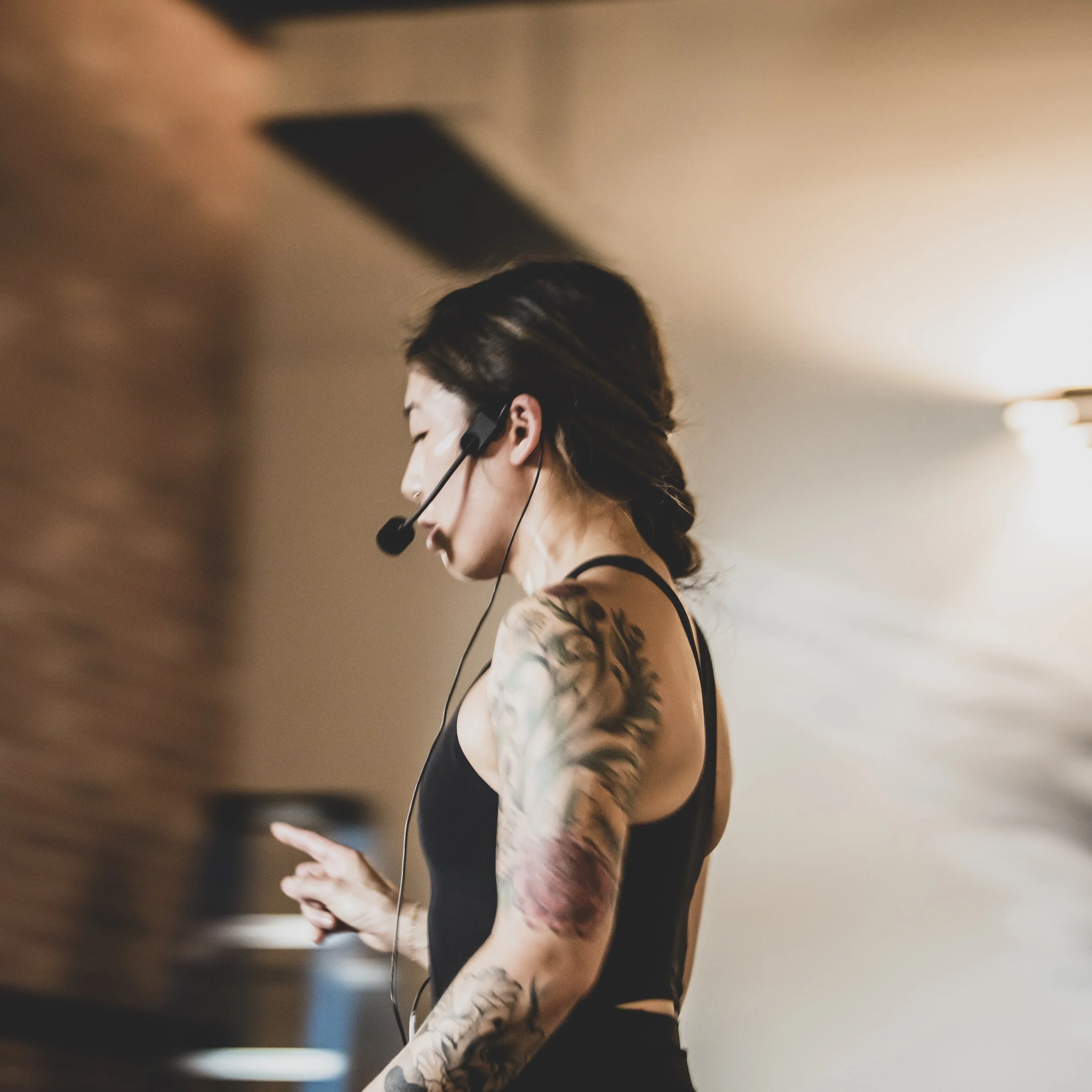 Yoga instructor with a microphone headset leading a yoga class