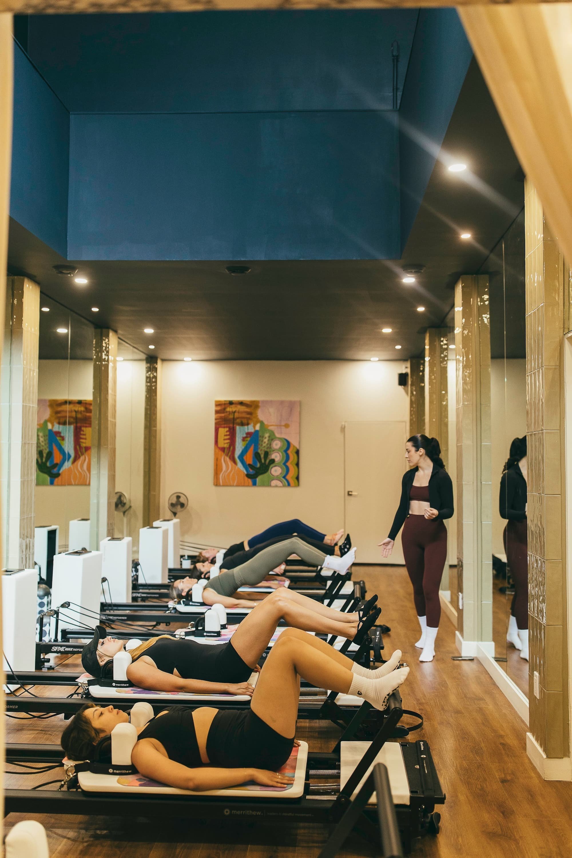 Women doing reformer pilates exercises in a studio