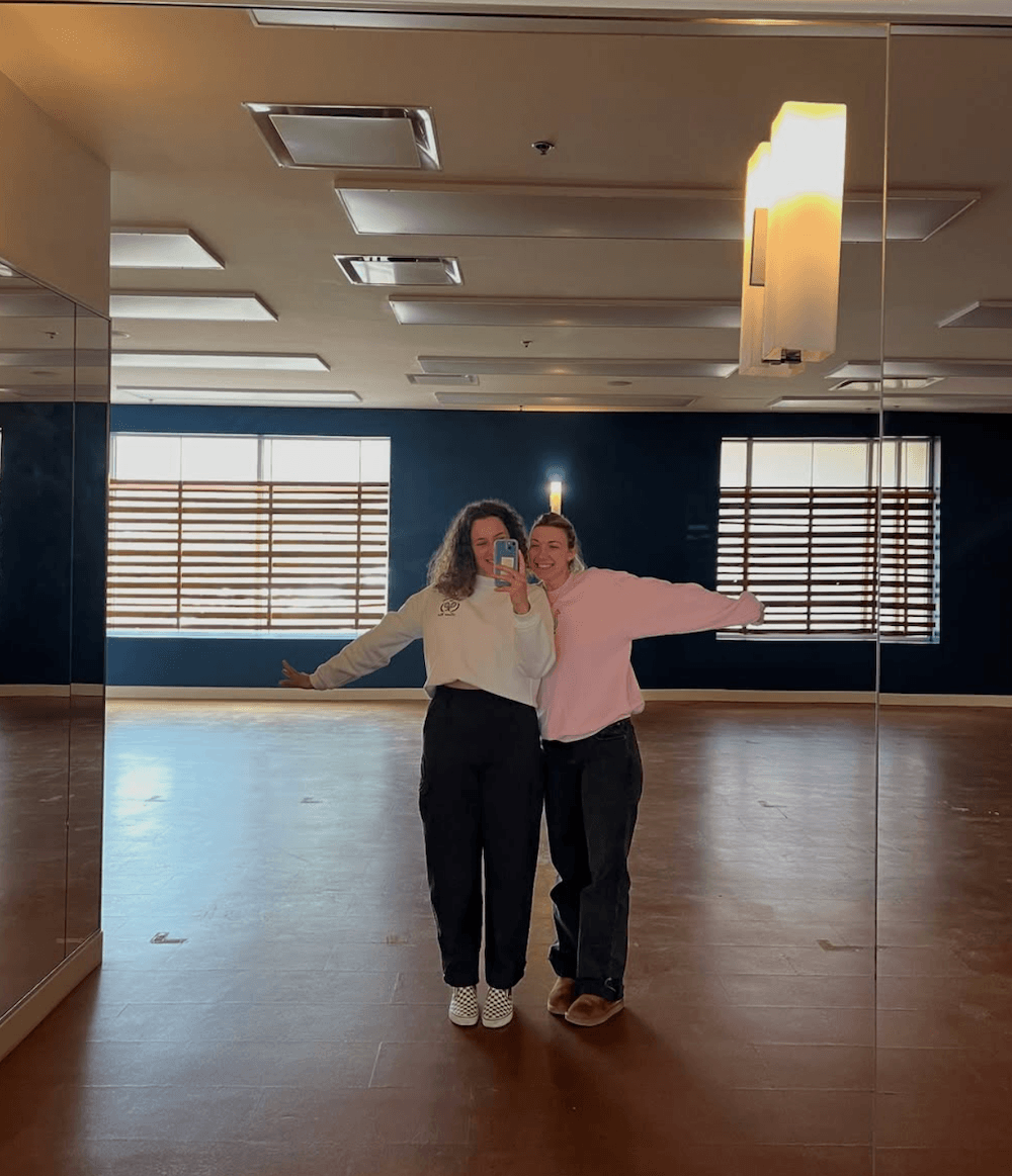 Founders take a self in the studio mirror, arms outstretched