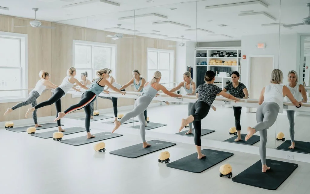 A group of women during a Barre class at a boutique fitness studio