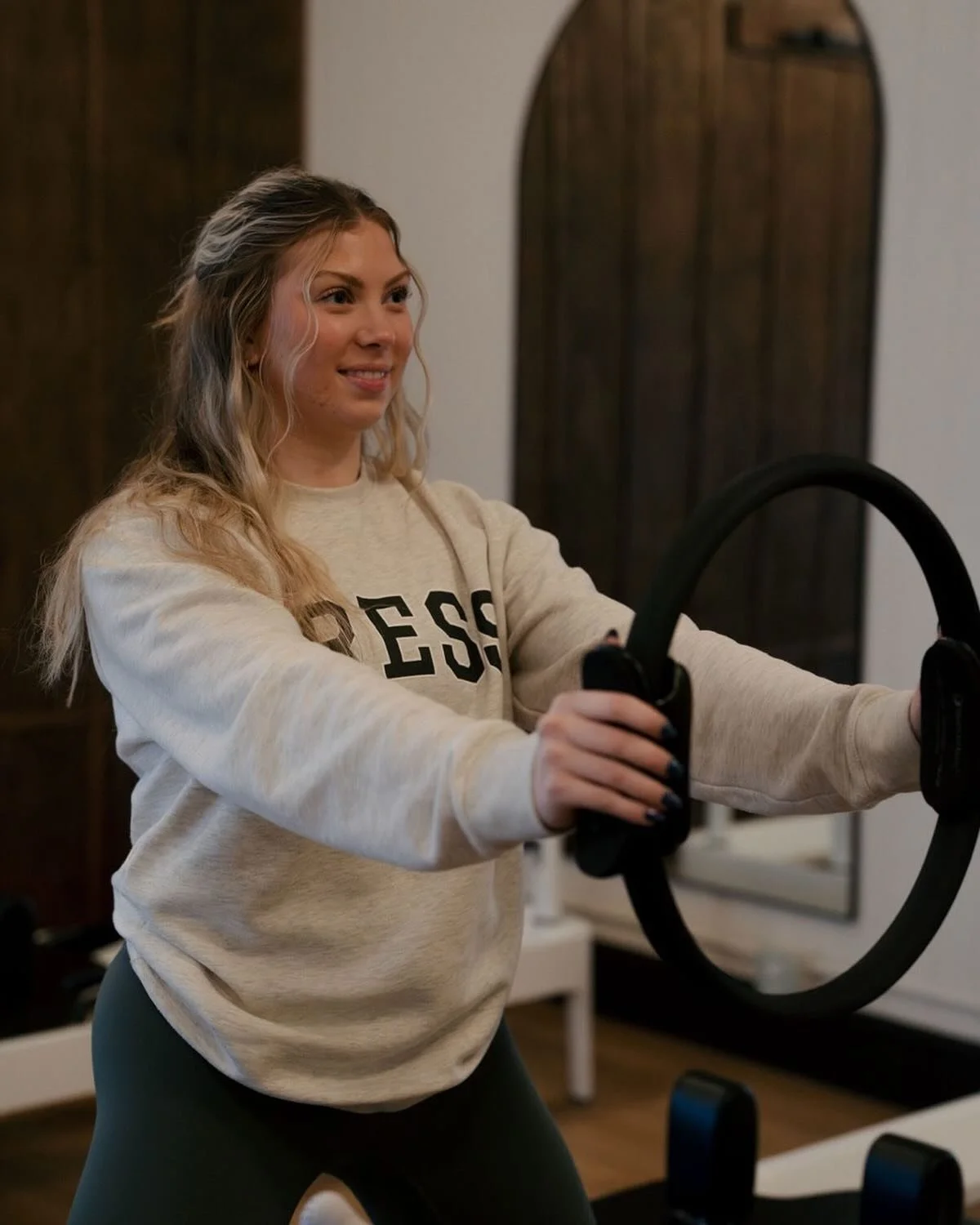 The Press Pilates instructor holding a Pilates ring while leading a class
