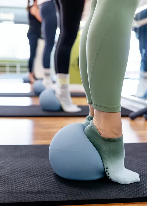 Pilates clients using exercise balls during a boutique fitness studio class