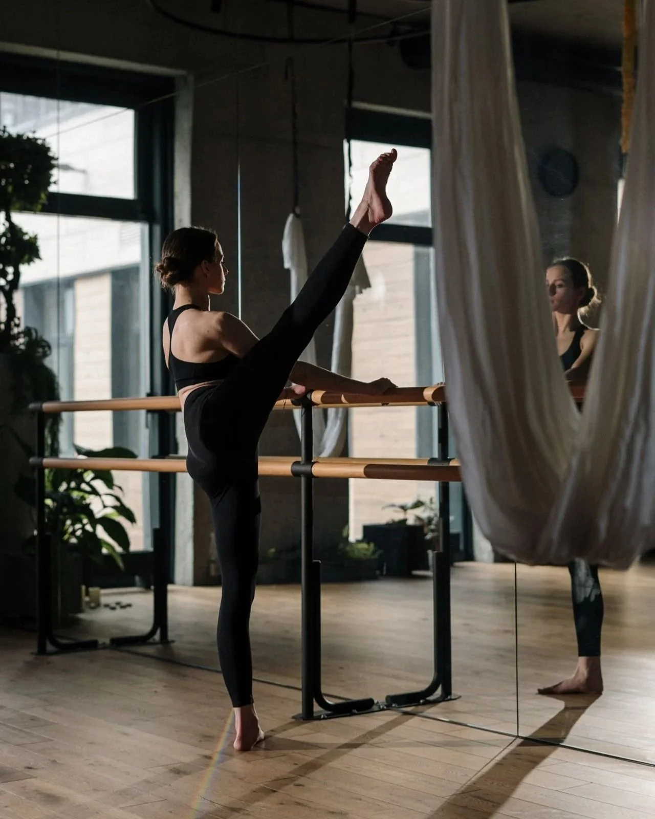 woman doing barre excersices in a boutique fitness studio