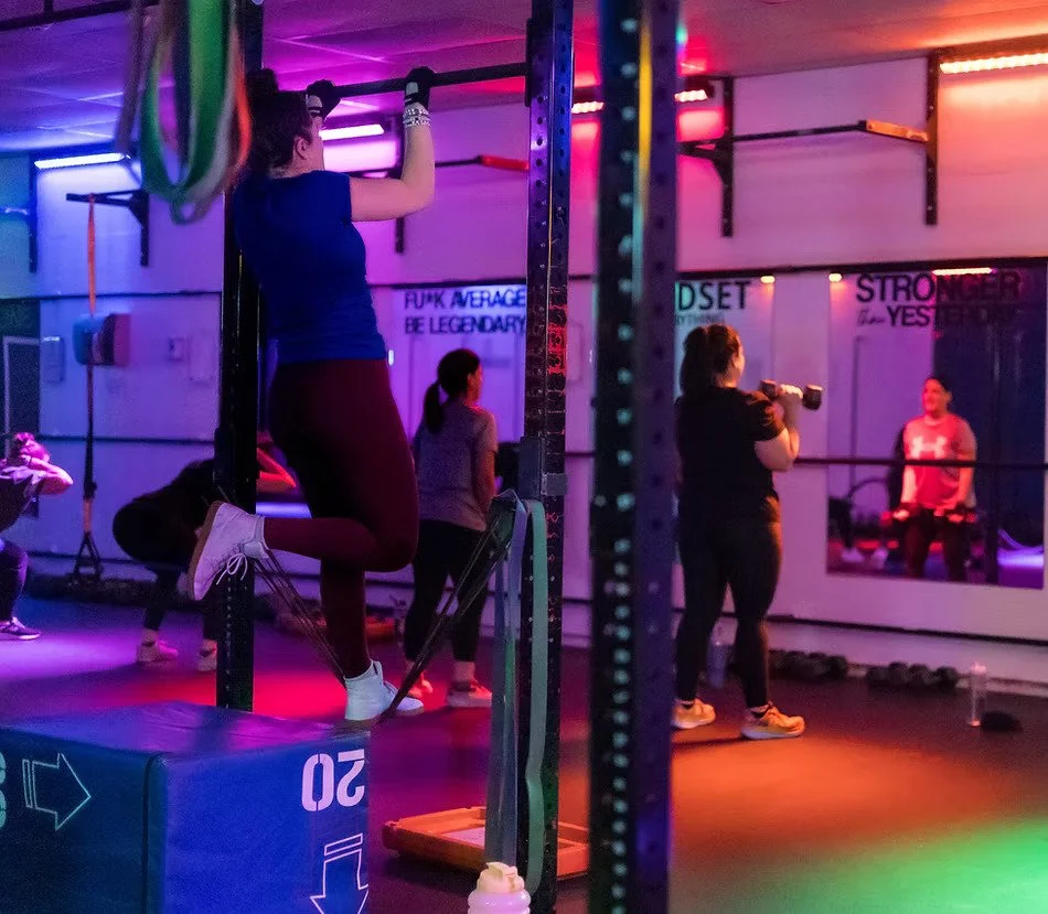 A woman doing a pull up in a fitness gym