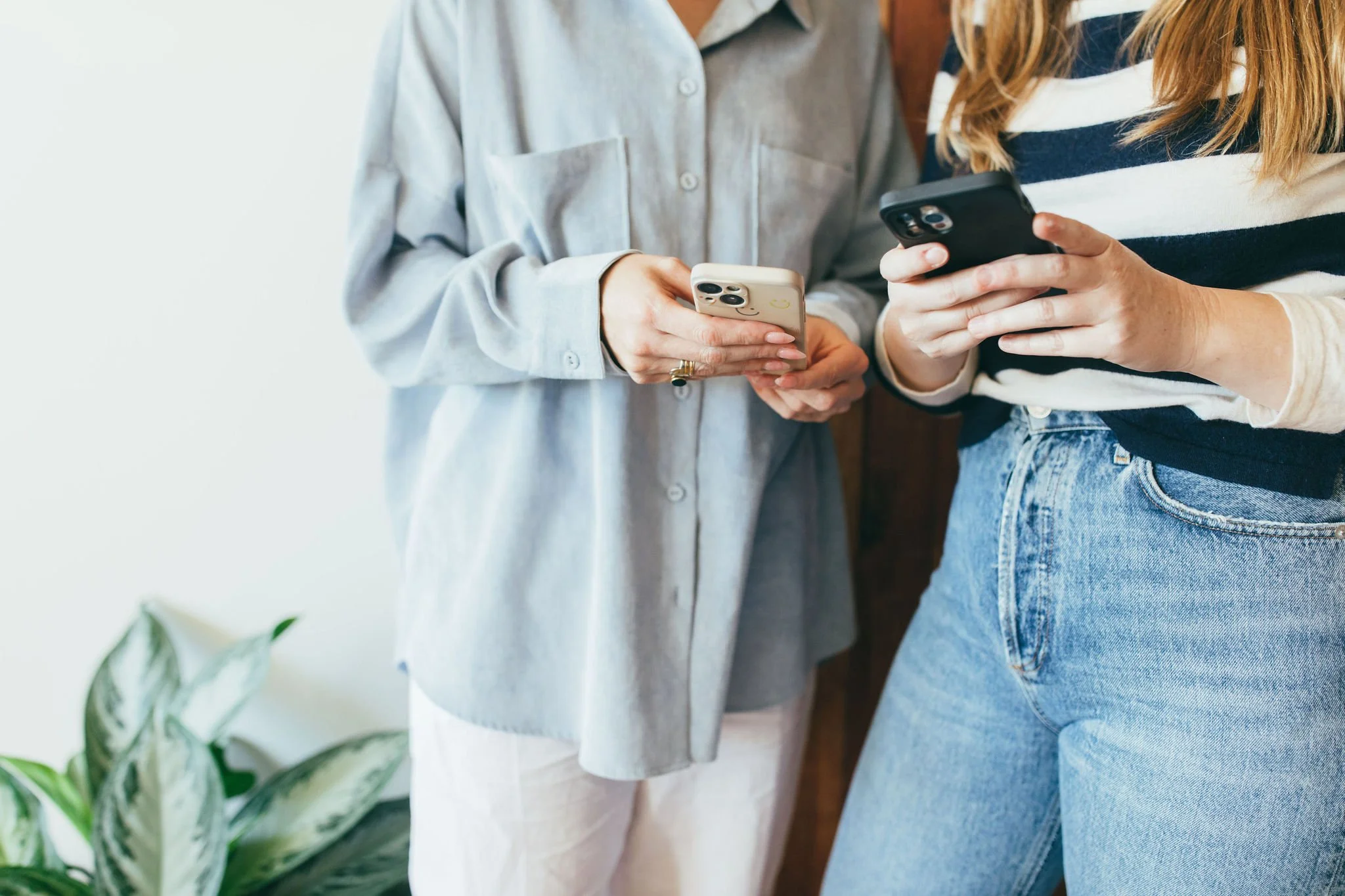 Two women doing a boutique fitness studio search on their phones