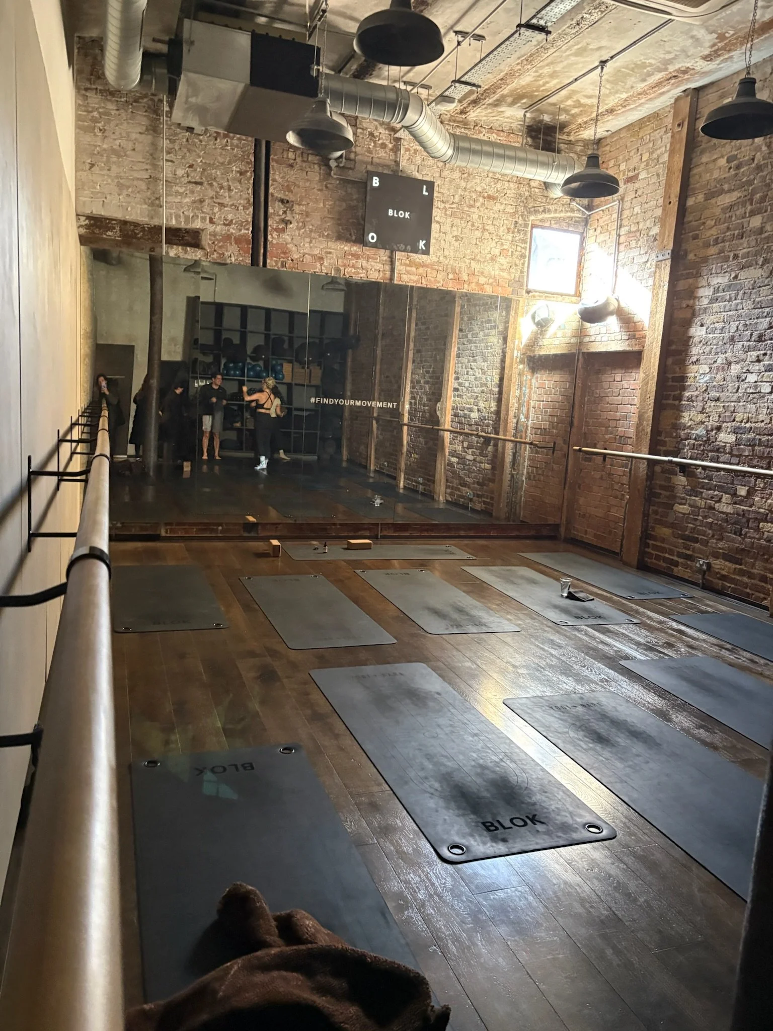 Victorian-style, empty boutique fitness studio room with Pilates mats on the floor