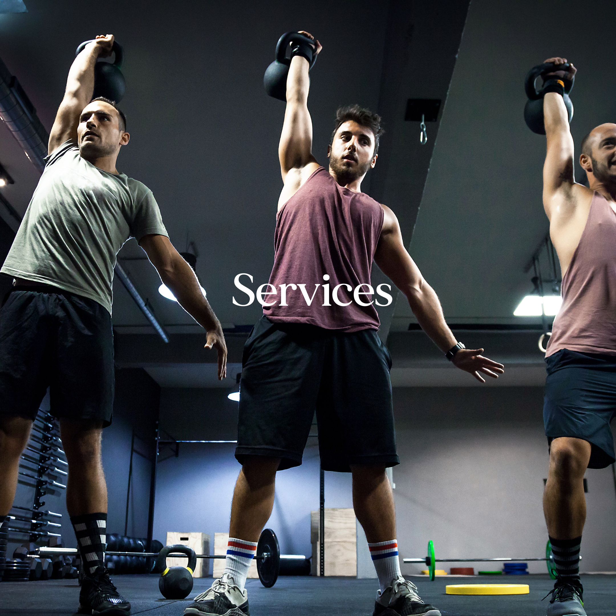 Three men are lifting kettlebells in a gym. They are all in workout attire, standing on a black mat, surrounded by gym equipment like dumbbells and weights. The room has a dark ceiling with industrial lighting. The word "Services" is overlaid.