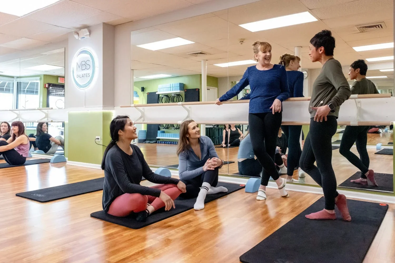 Four MBS Pilates instructors having a chat after a teacher training session.