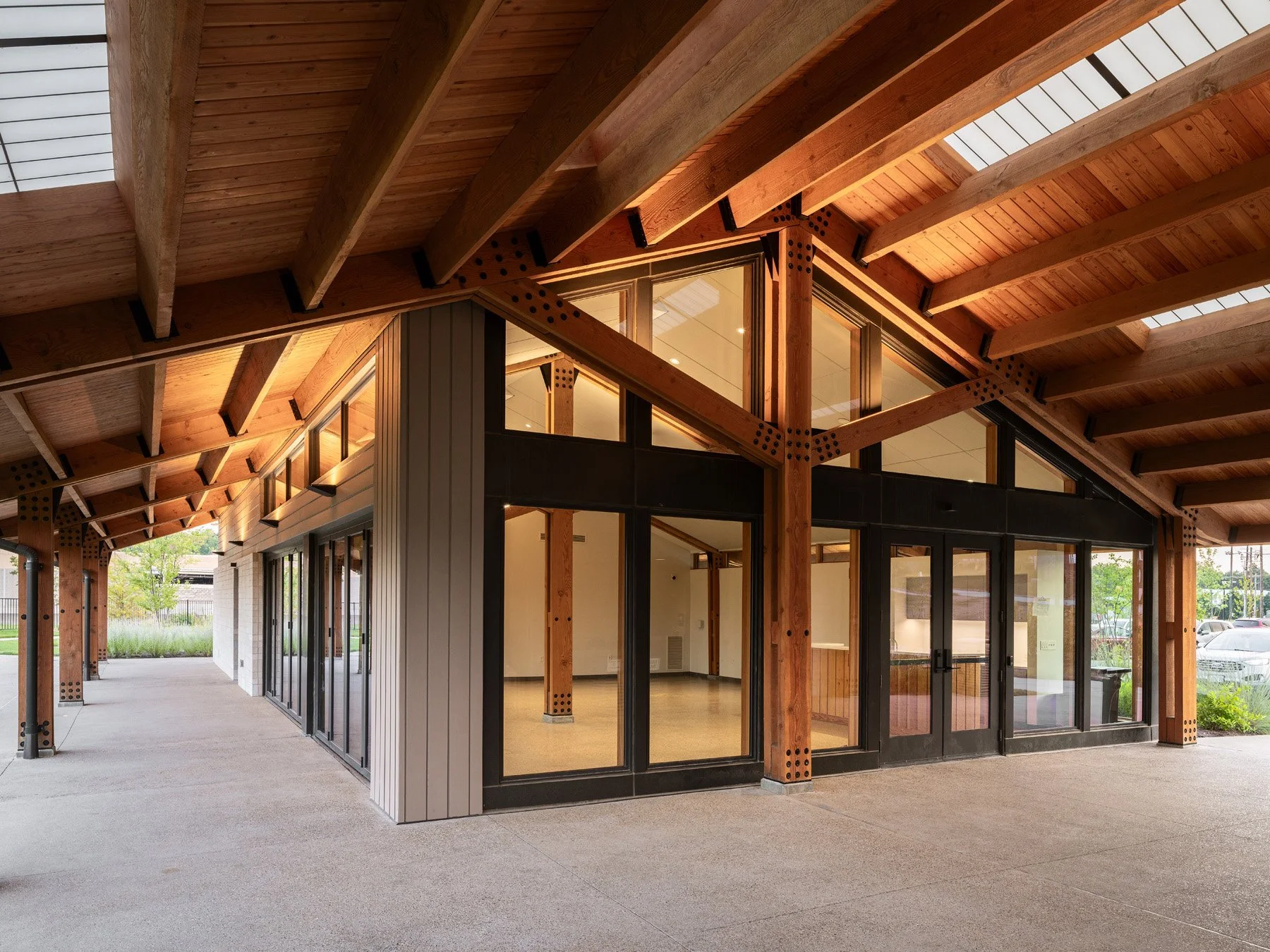 Brentwood Park Event Pavilion covered porch with exposed heavy-timber frame and glazed event hall, by Christner - architectural photographer St. Louis Missouri