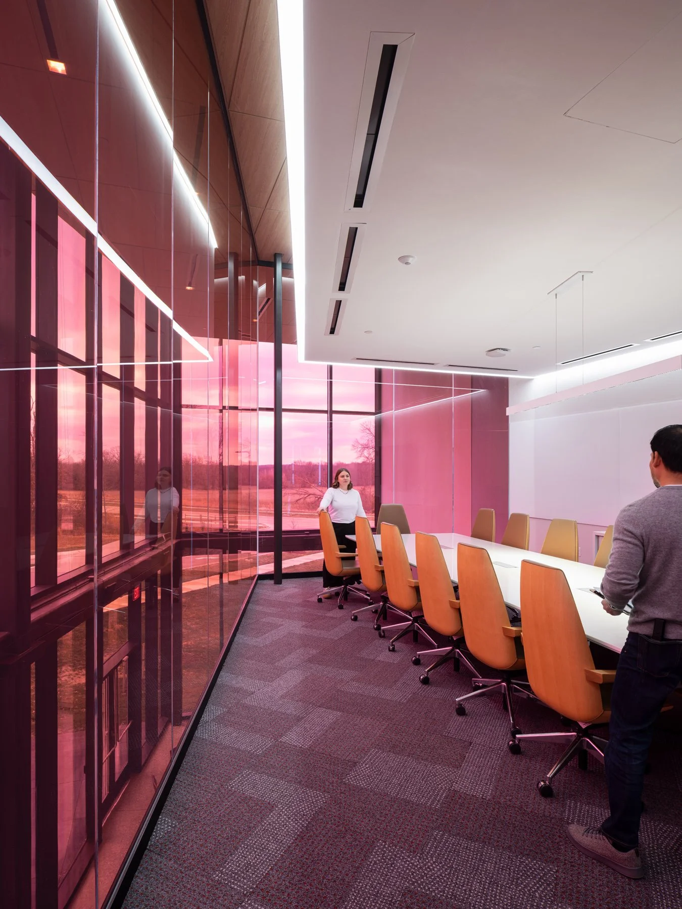 Regional Workforce Innovation Center conference room inside the tinted glass volume at dusk with a magenta sunset through the curtain wall, Wentzville, Missouri, by JEMA - architectural photographer St. Louis Missouri