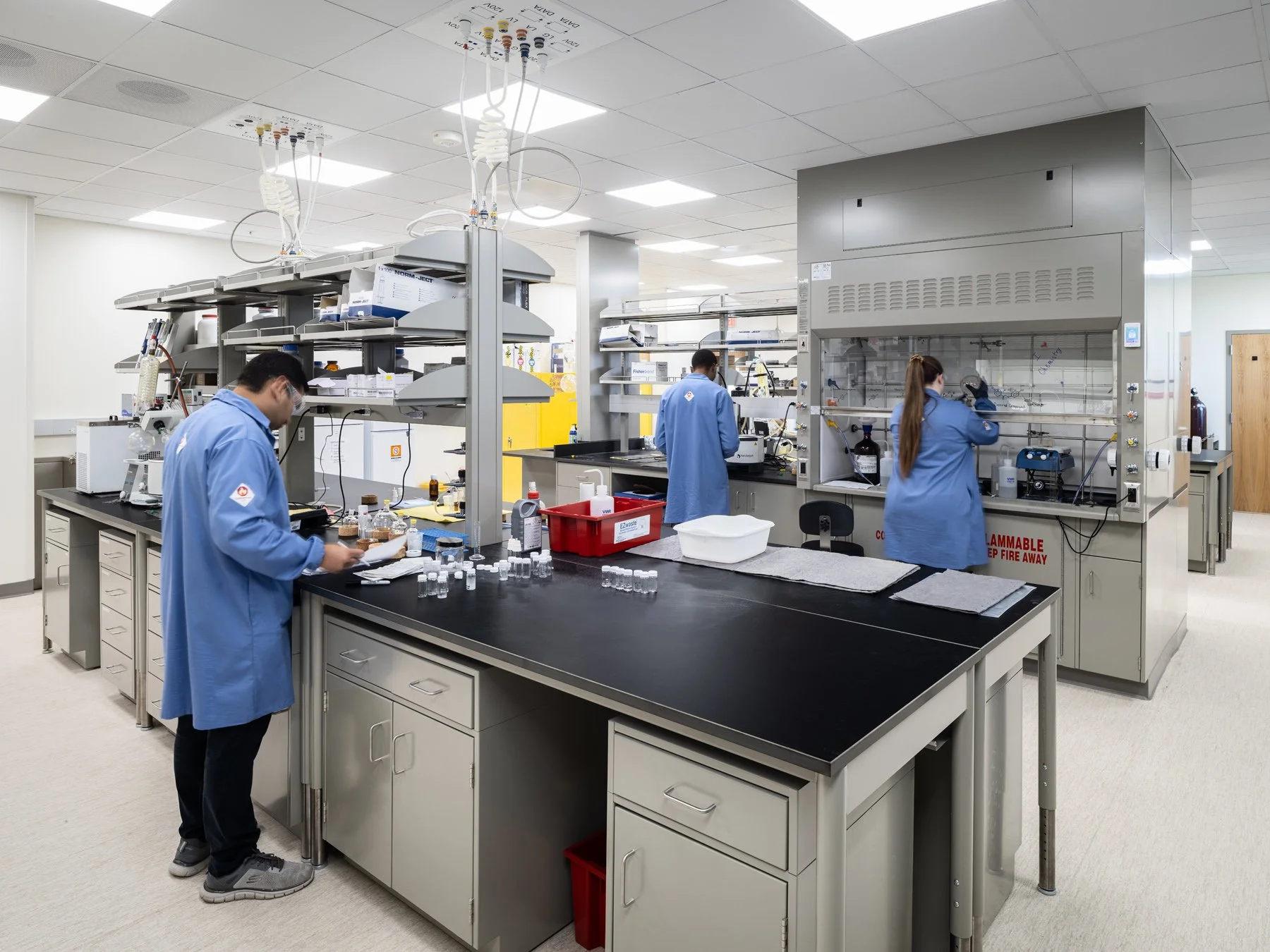 SIUE Health Sciences chemistry lab with students in blue coats and a fume hood by Christner, Edwardsville Illinois - architectural photographer St. Louis