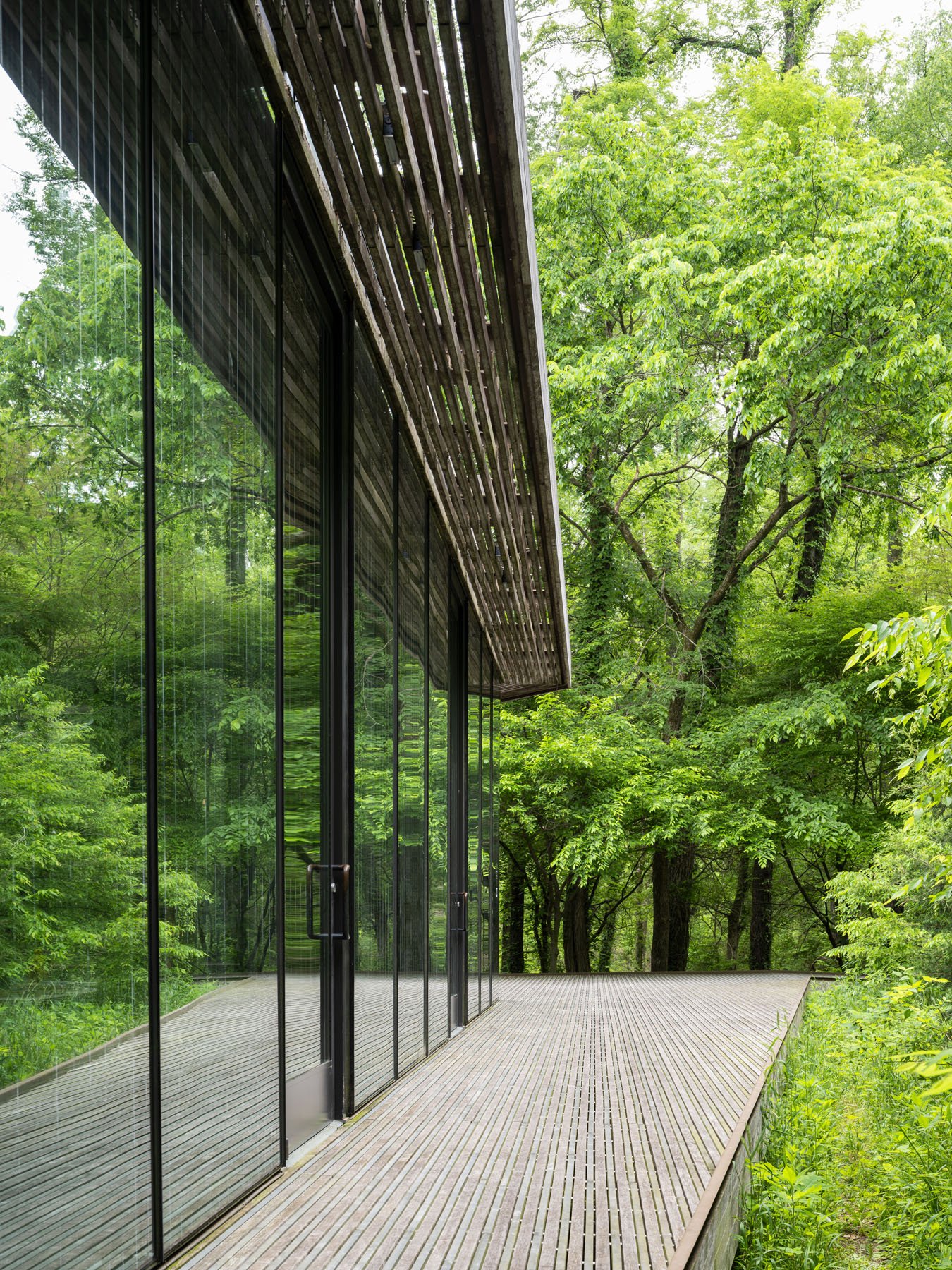 Ruth Lilly Visitors Pavilion side elevation with full-height glass wall, slatted overhang, and elevated wood deck, by Marlon Blackwell Architects, Indianapolis Indiana - architectural photographer