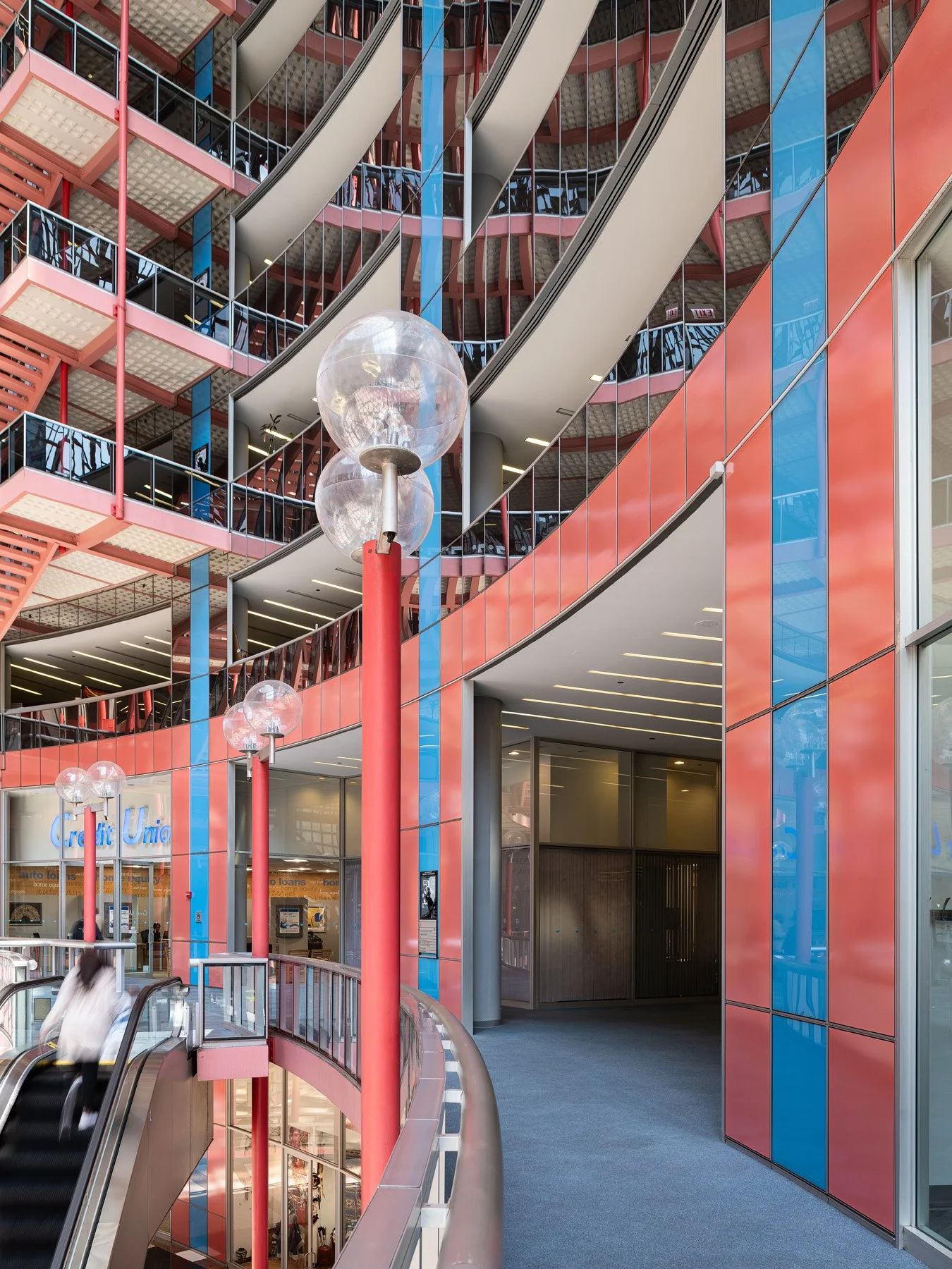 James R. Thompson Center interior with clustered globe lights on red posts beside curving tiers, Chicago - postmodern light fixtures