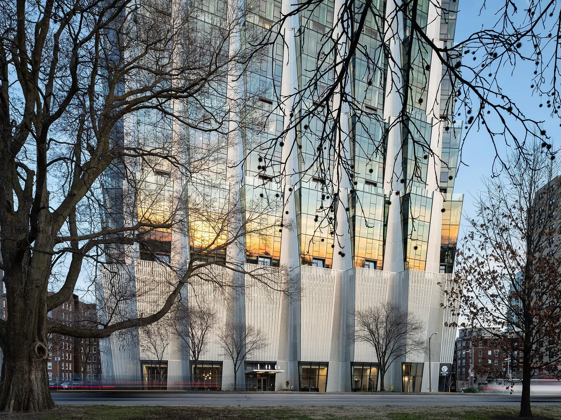 One Hundred Above the Park lower facade at dusk, corrugated aluminum fins and glass reflecting sunset, by Studio Gang - architectural photographer St. Louis Missouri