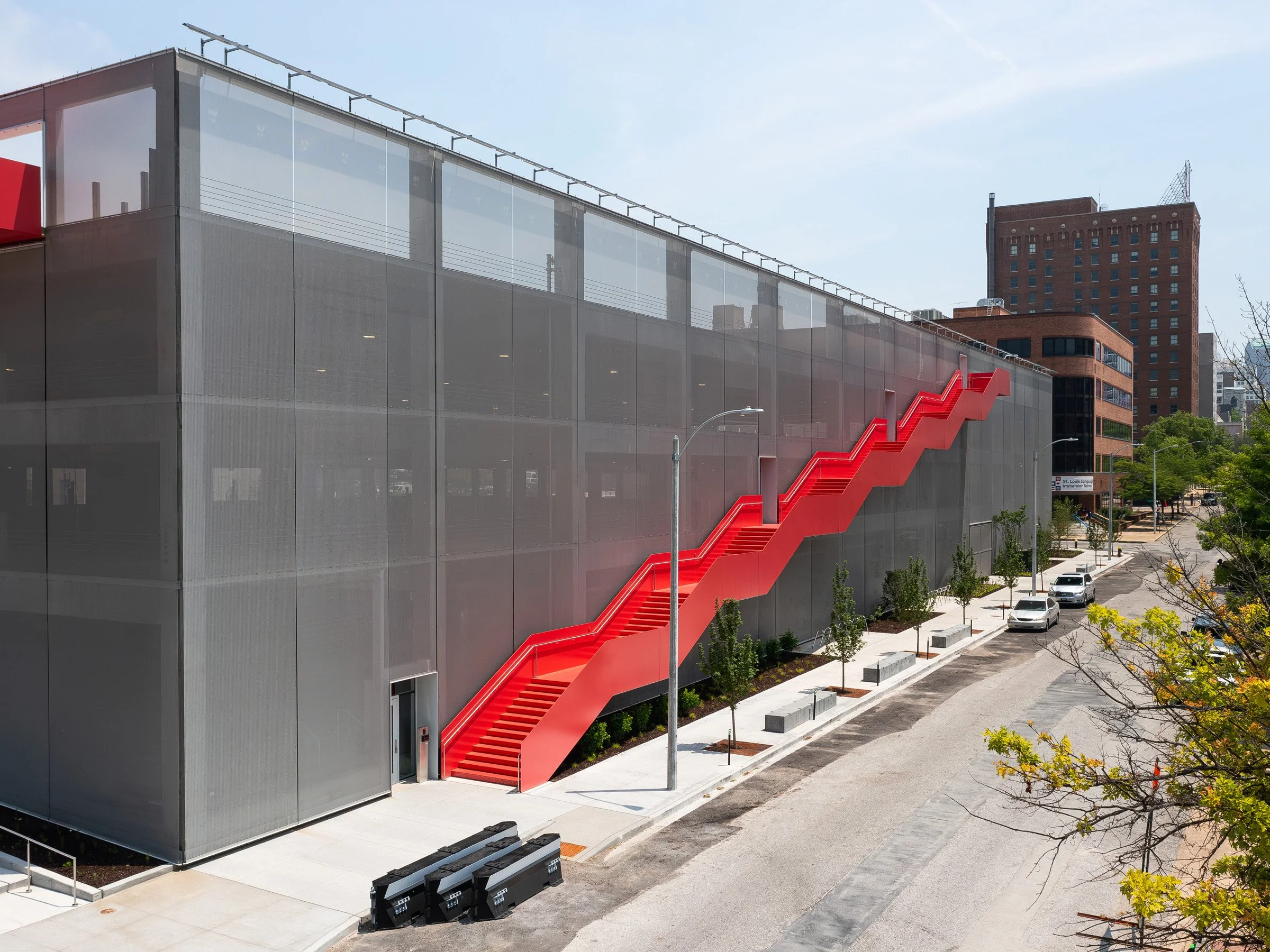 Energizer Park parking garage exterior by day with a perforated metal screen facade and a bright red exterior stair, St. Louis Missouri - architectural photographer St. Louis Missouri