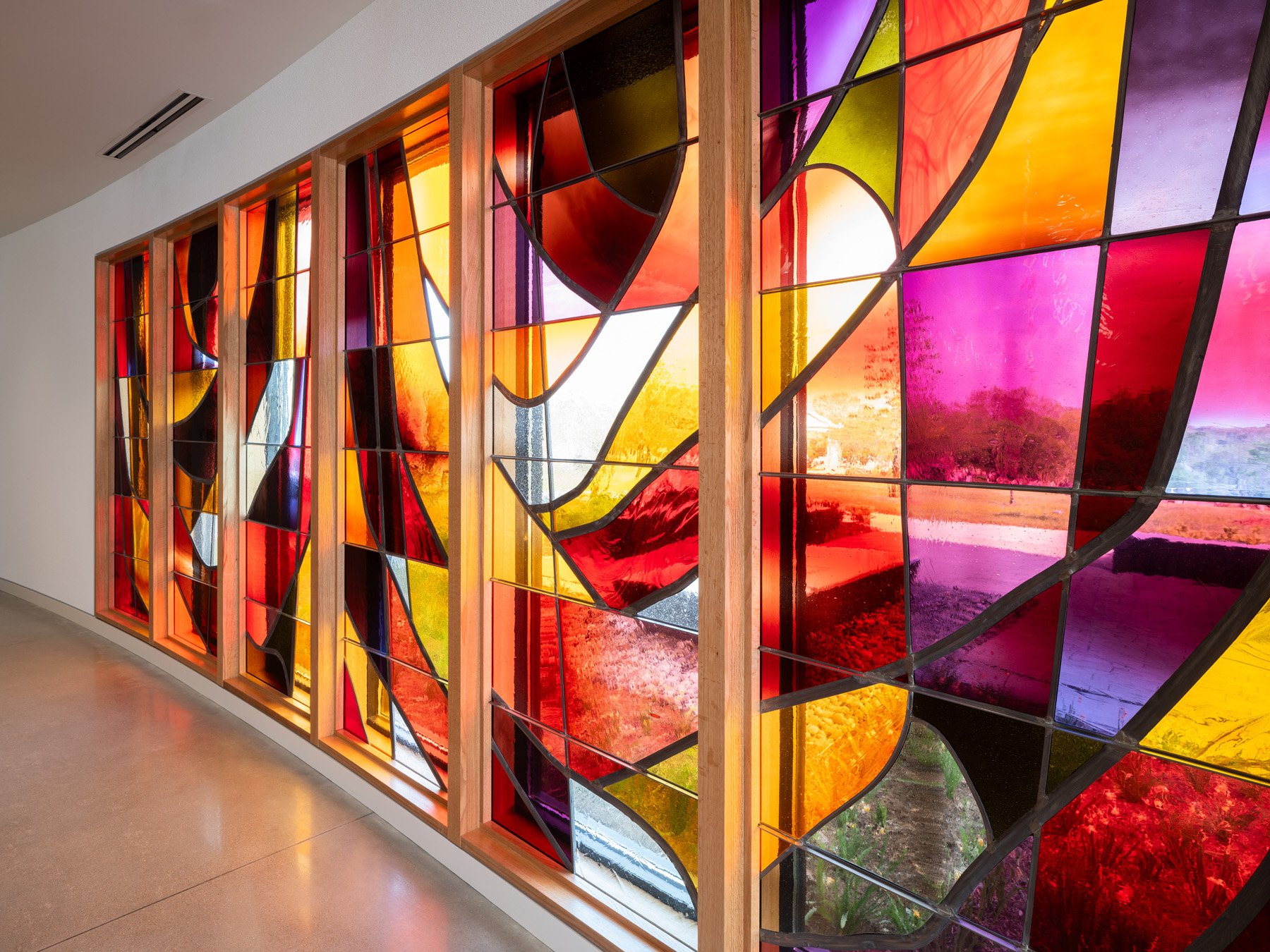 Chapel of the Risen Christ corridor wall of vivid colored stained glass, by Emil Frei & Associates - architectural photographer St. Louis Missouri