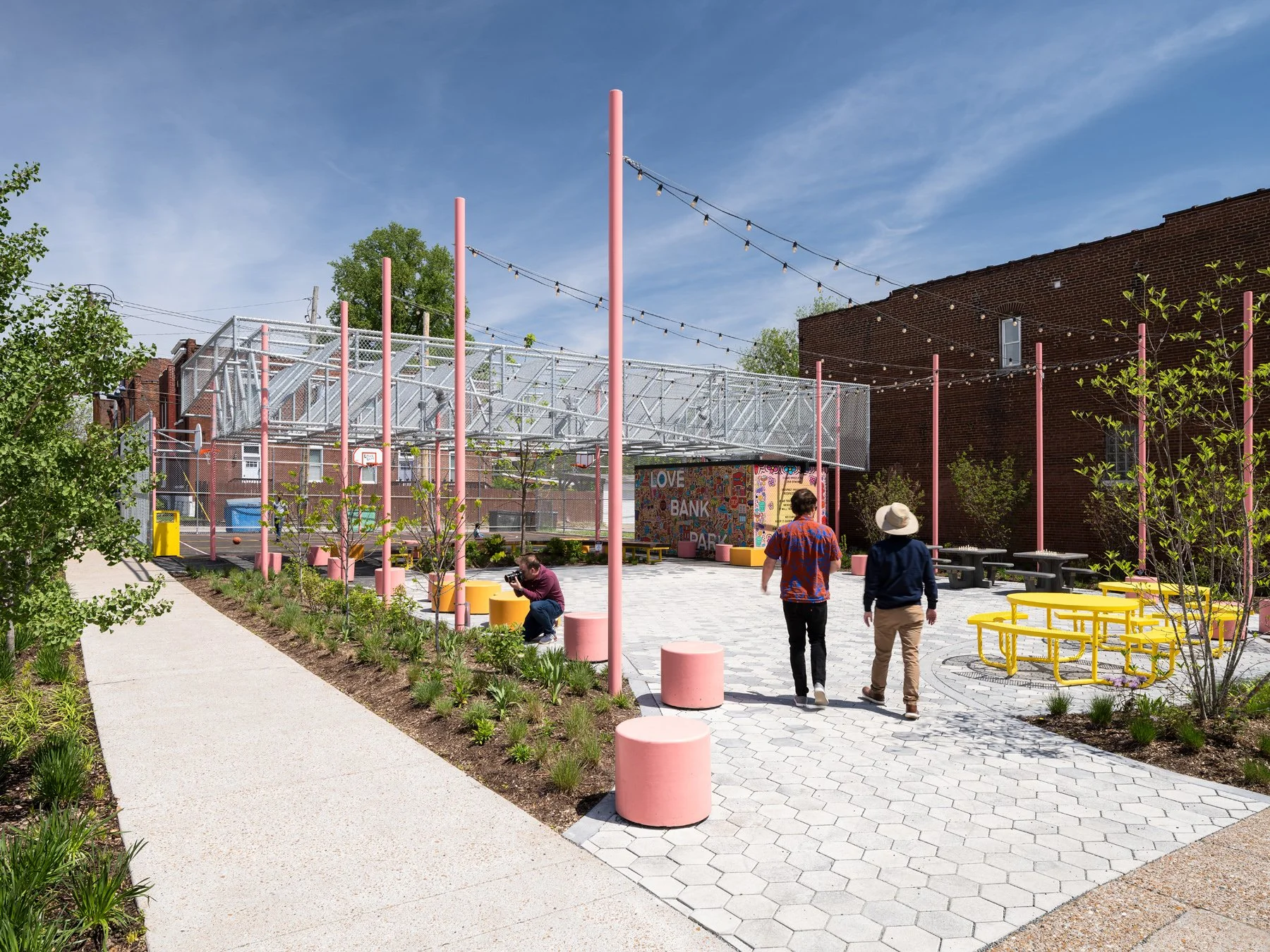 Love Bank Park hex-paved plaza with planting beds and yellow tables, landscape by Arbolope Studio - architectural photographer St. Louis Missouri
