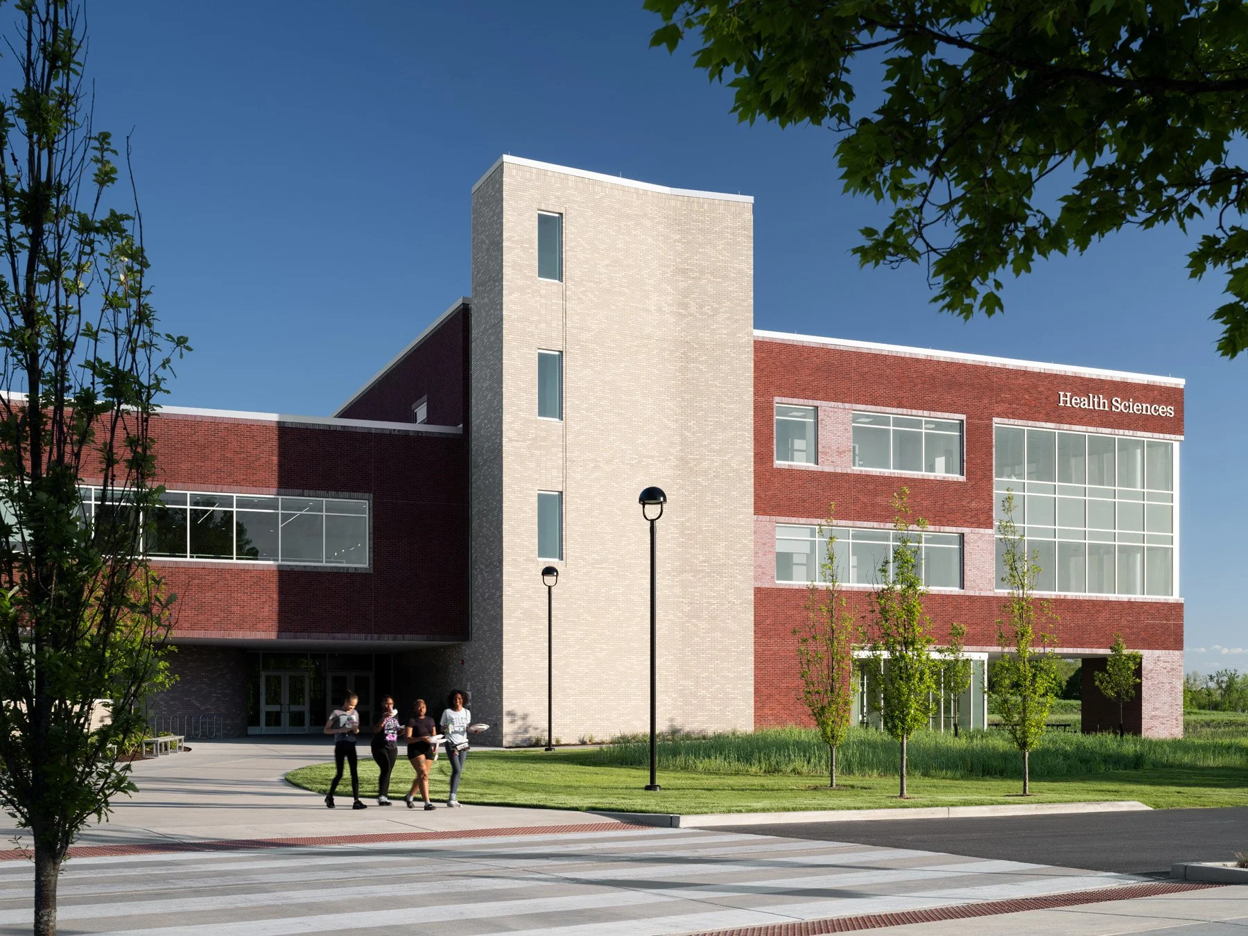 SIUE Health Sciences entry plaza with a limestone stair tower and students by Christner, Edwardsville Illinois - architectural photographer St. Louis