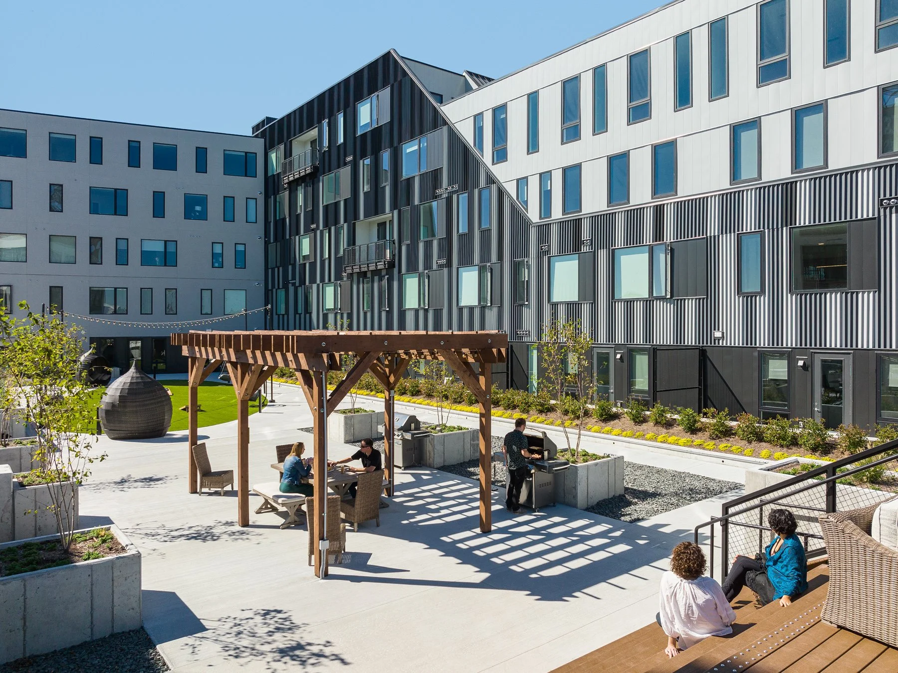 Steelcote Flats courtyard timber pergola and grill stations with residents, by Trivers - architectural photographer St. Louis Missouri