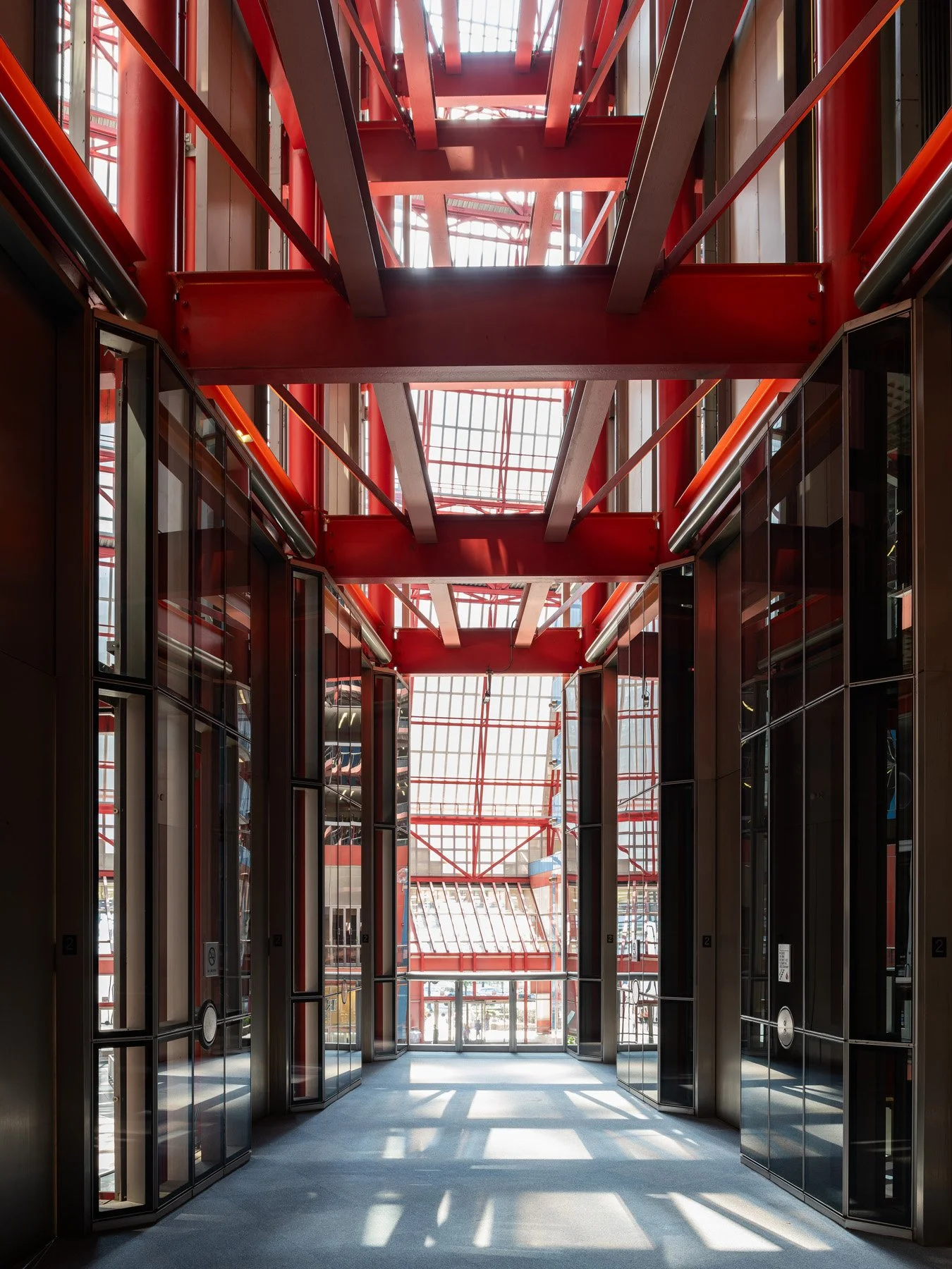 James R. Thompson Center entry vestibule framed by mirrored walls and red steel beams overhead, Chicago - red space frame