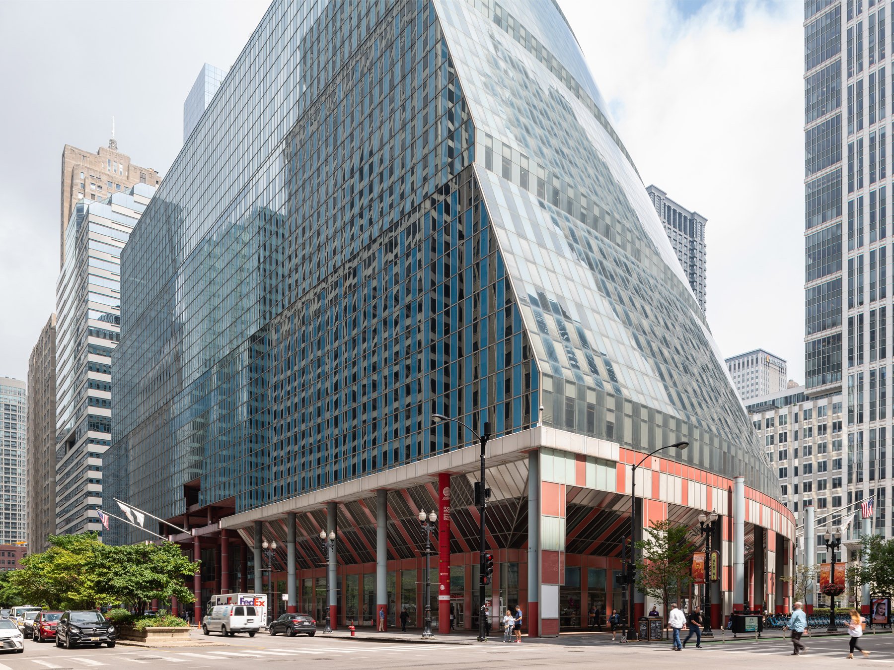 James R. Thompson Center on the street corner, the great curved facade raking up from the salmon arcade, Chicago - sloping glass curtain wall