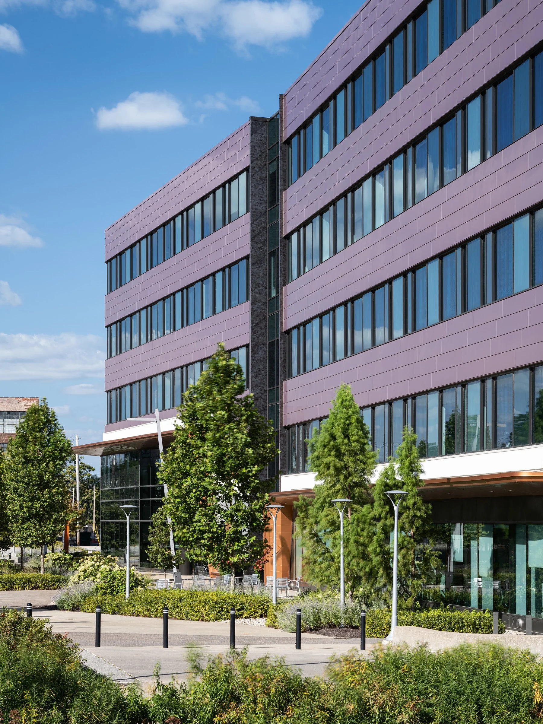 4220 Duncan copper-rose facade with masonry spine above entry and plaza landscaping, by HOK - architectural photographer St. Louis Missouri