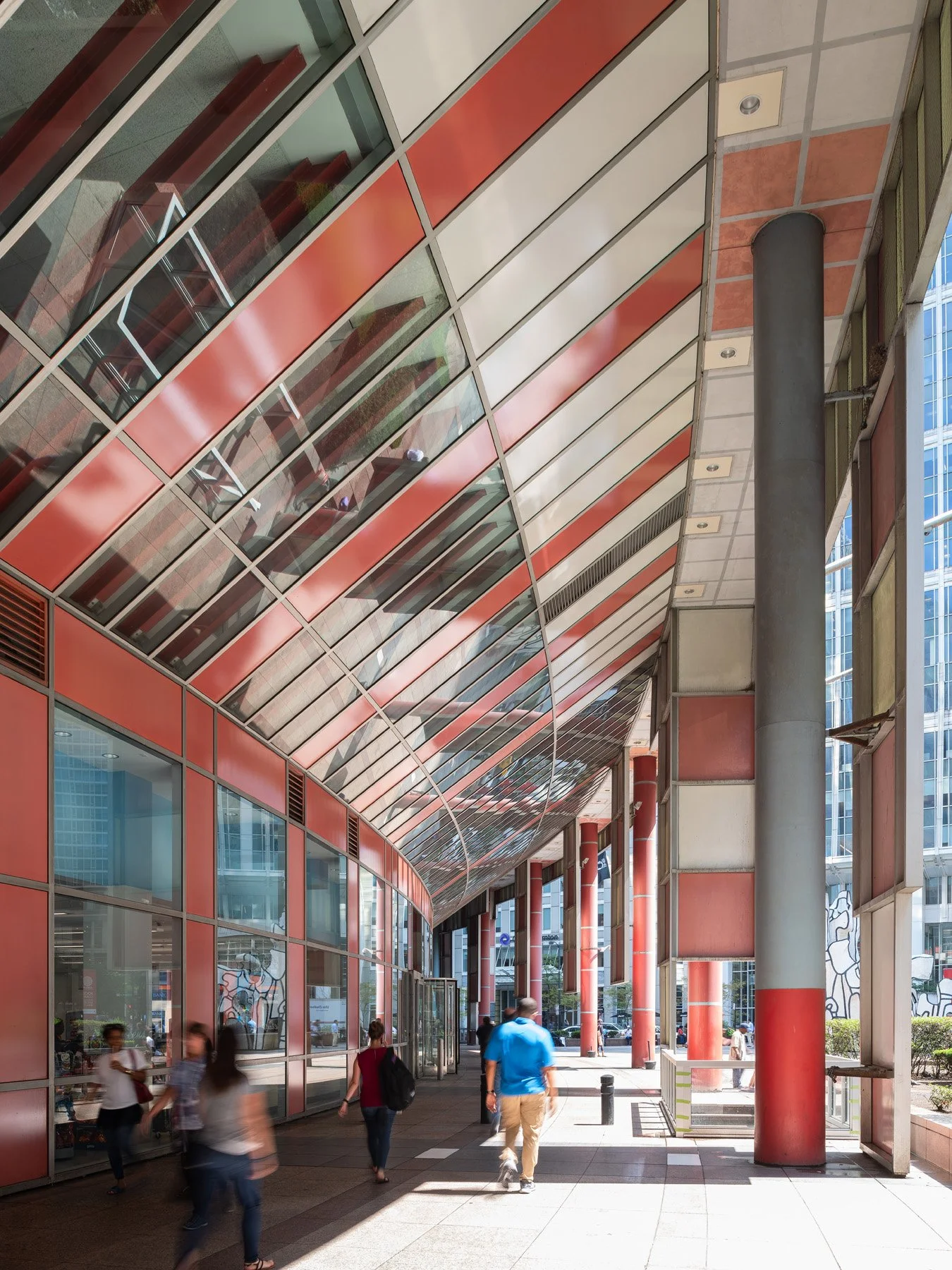 James R. Thompson Center exterior colonnade, salmon soffit and red columns curving along the glass, Chicago - curving glass canopy